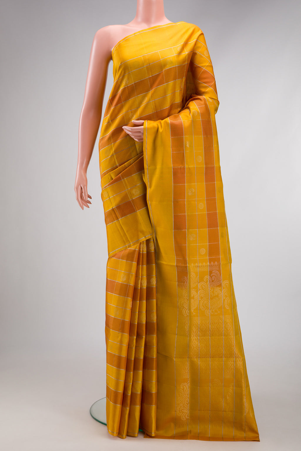 Mustard Soft Silk Saree with Checked design on the body and Plain Border.  displayed on a mannequin