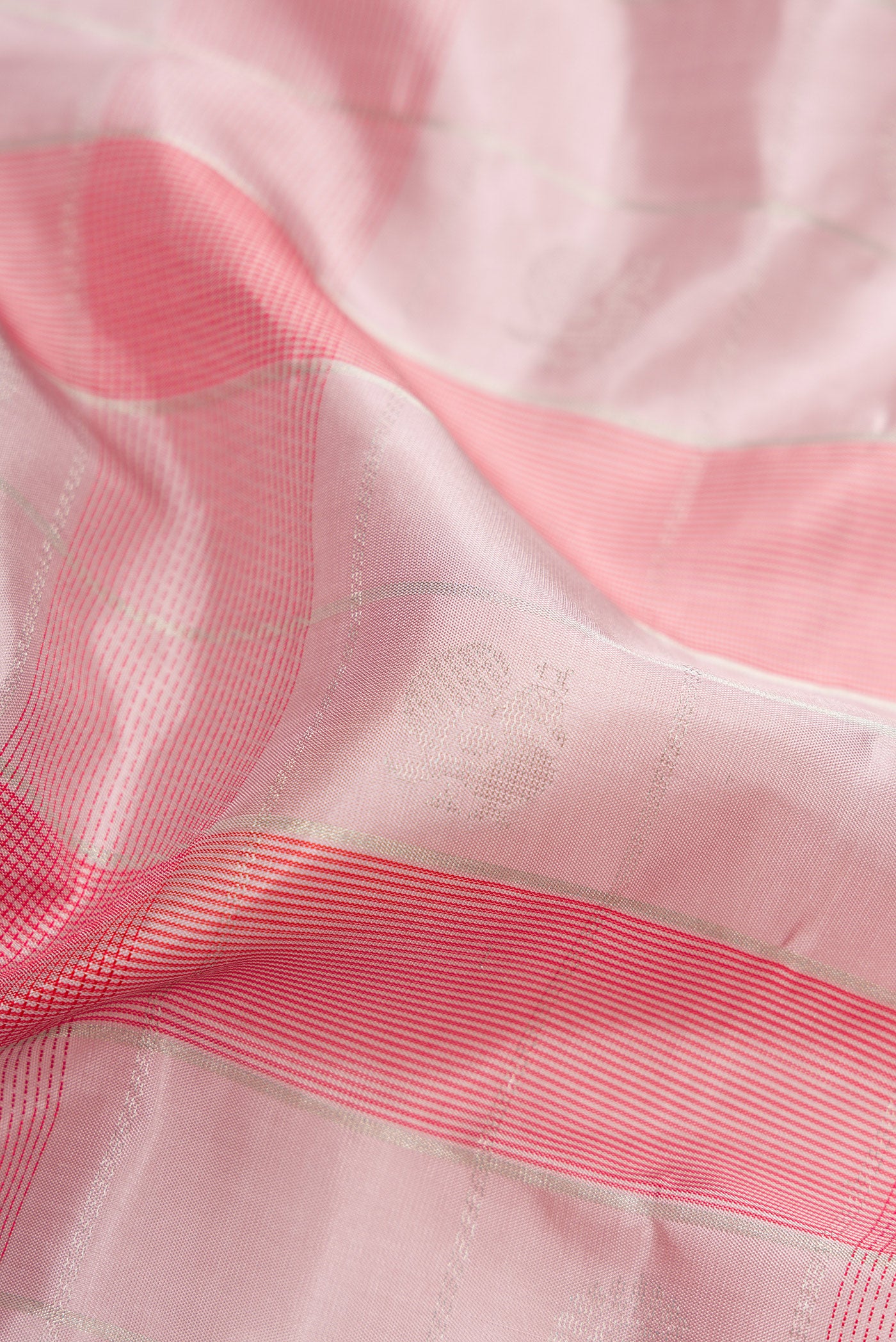 Close up of Rose Gold Soft Silk Saree with Checked design on the body and Plain Border.  displaying folds