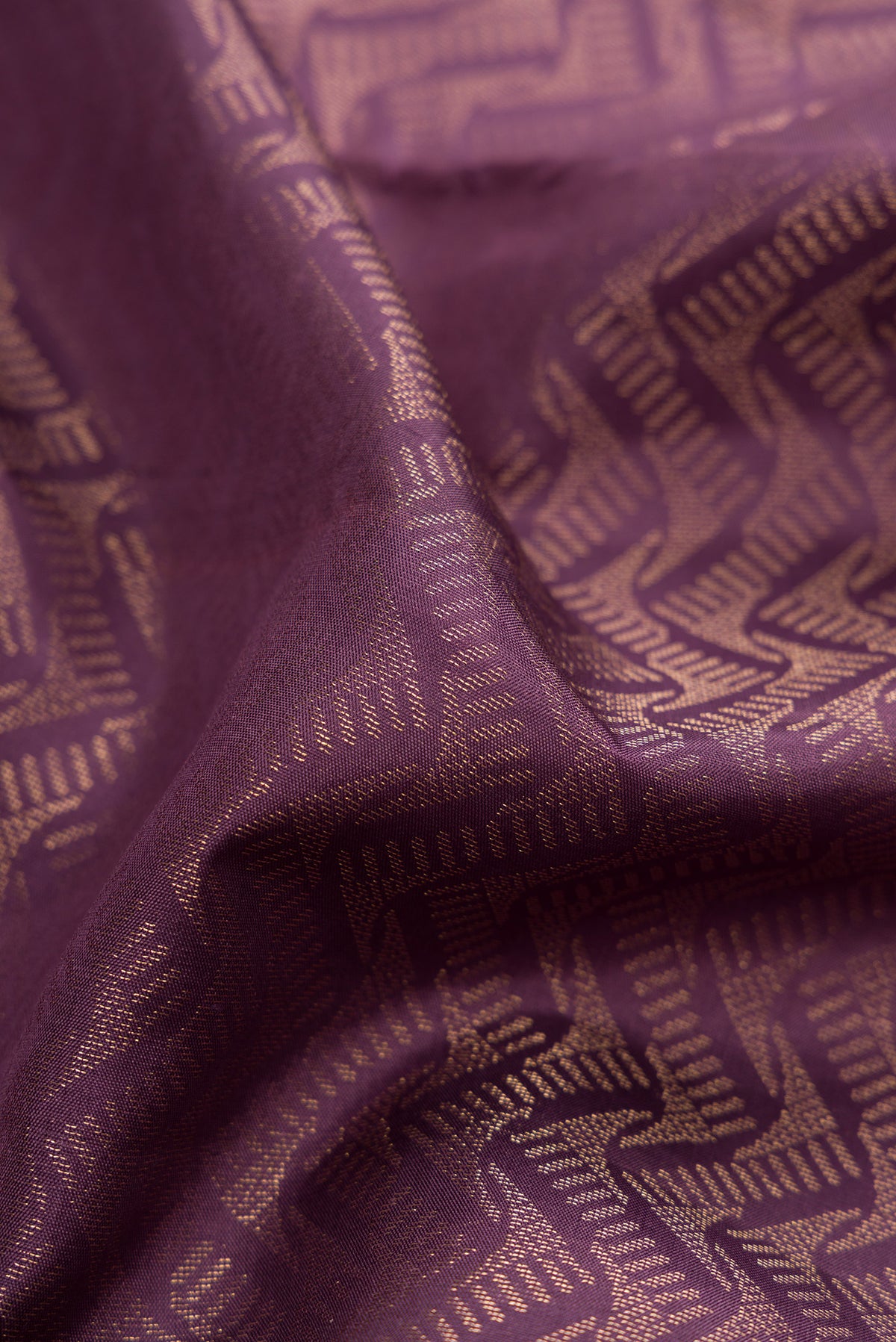Close up of Purple Soft Silk Saree with Zari Brocade on the body and Fancy Border.  displaying folds
