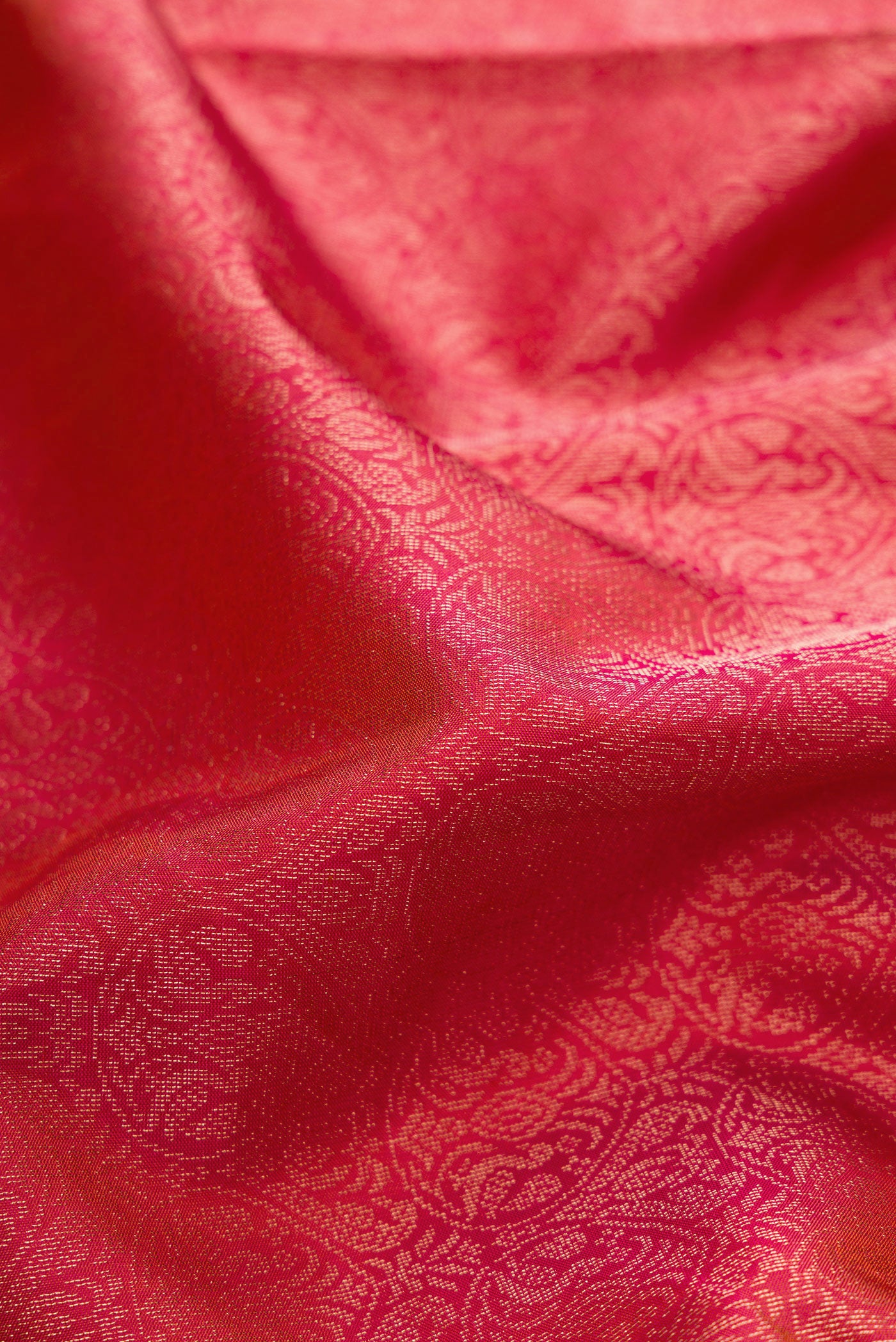 Close up of Coral Soft Silk Saree with Zari Brocade on the body and Fancy Border.  displaying folds