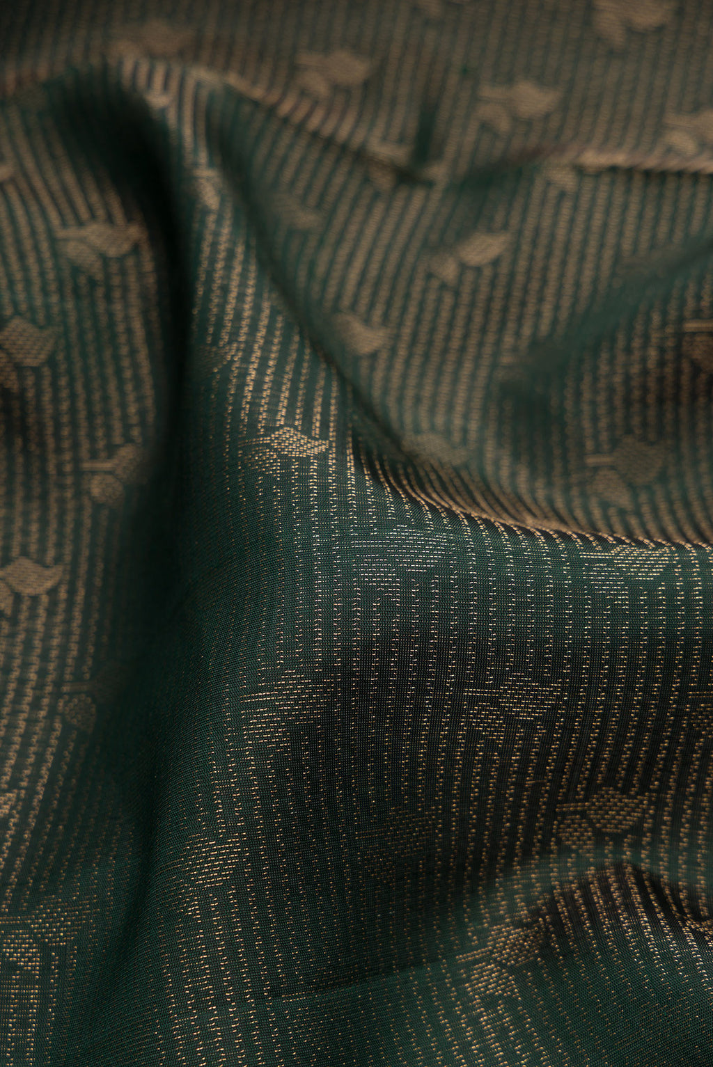 Close up of Bottle Green Soft Silk Saree with Zari Brocade on the body and Fancy Border.  displaying folds