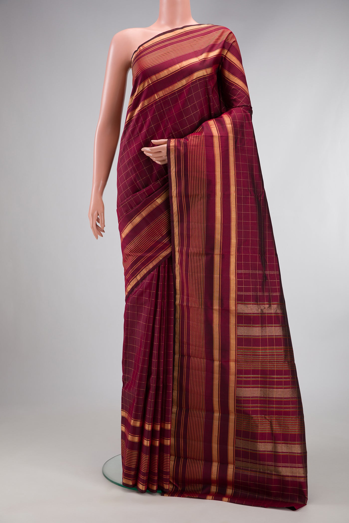 Maroon Kanjivaram Silk Saree with Checked design on the body and Zari Border.  displayed on a mannequin