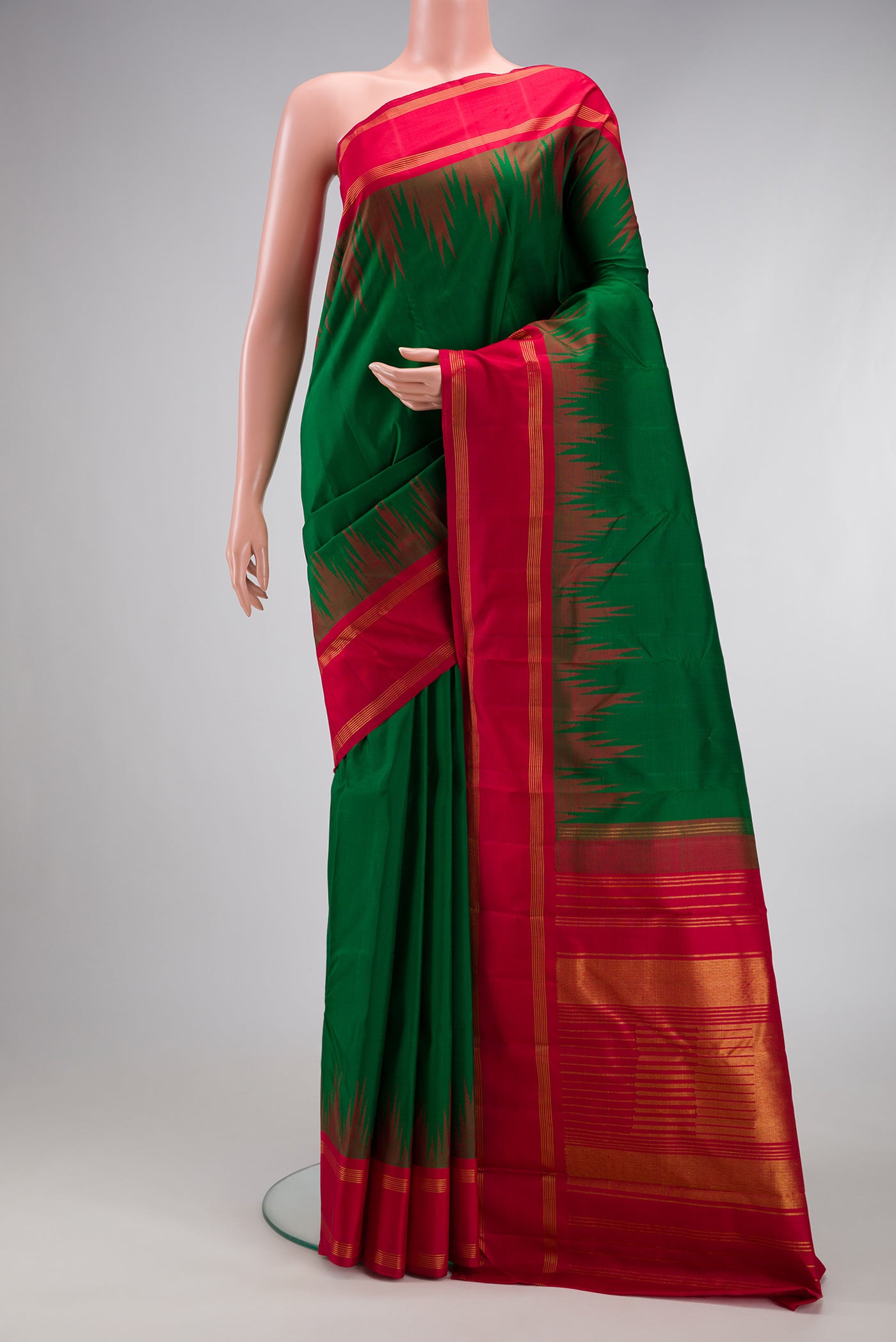 Bottle Green Kanjivaram Silk Saree with Plain Body and Temple Border.  displayed on a mannequin