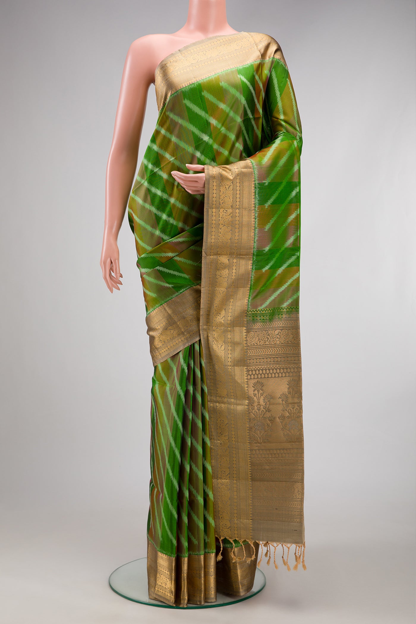 Green Soft Silk Saree with Ikat design on the body and Zari Border.  displayed on a mannequin