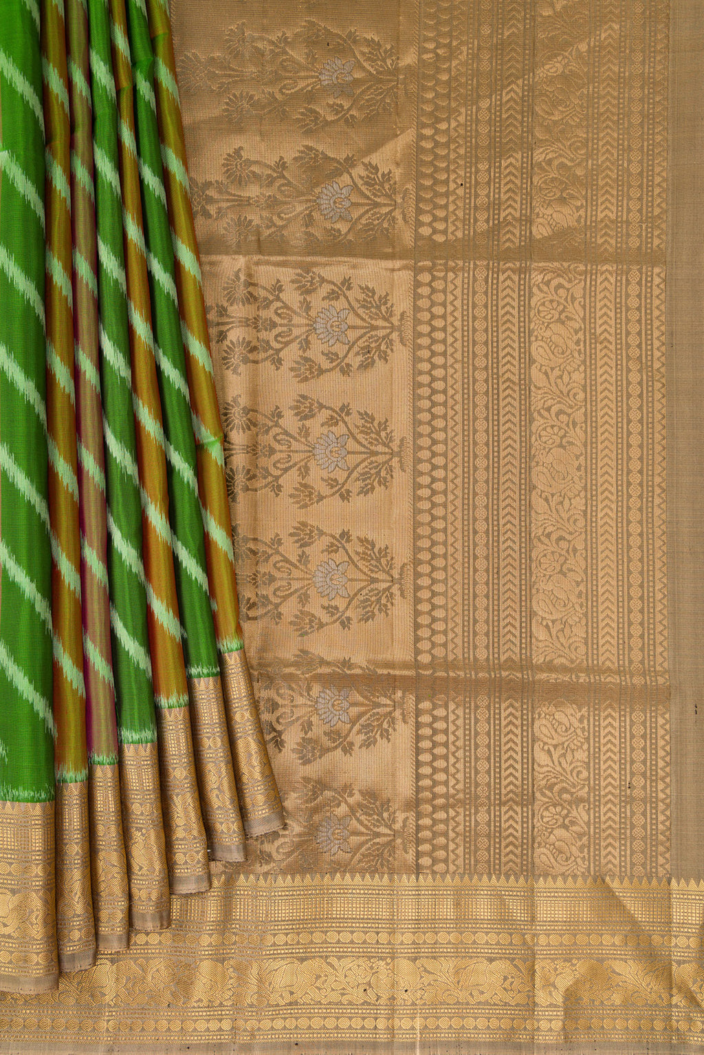 Pleats and pallu of Green Soft Silk Saree with Ikat design on the body and Zari Border. 