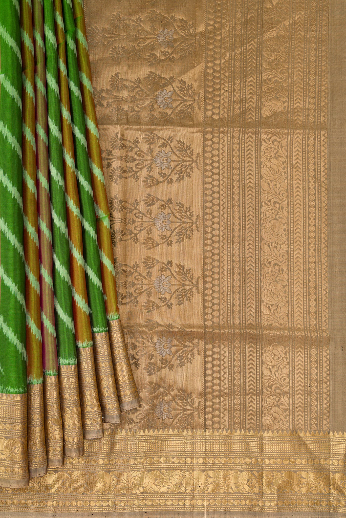 Pleats and pallu of Green Soft Silk Saree with Ikat design on the body and Zari Border. 