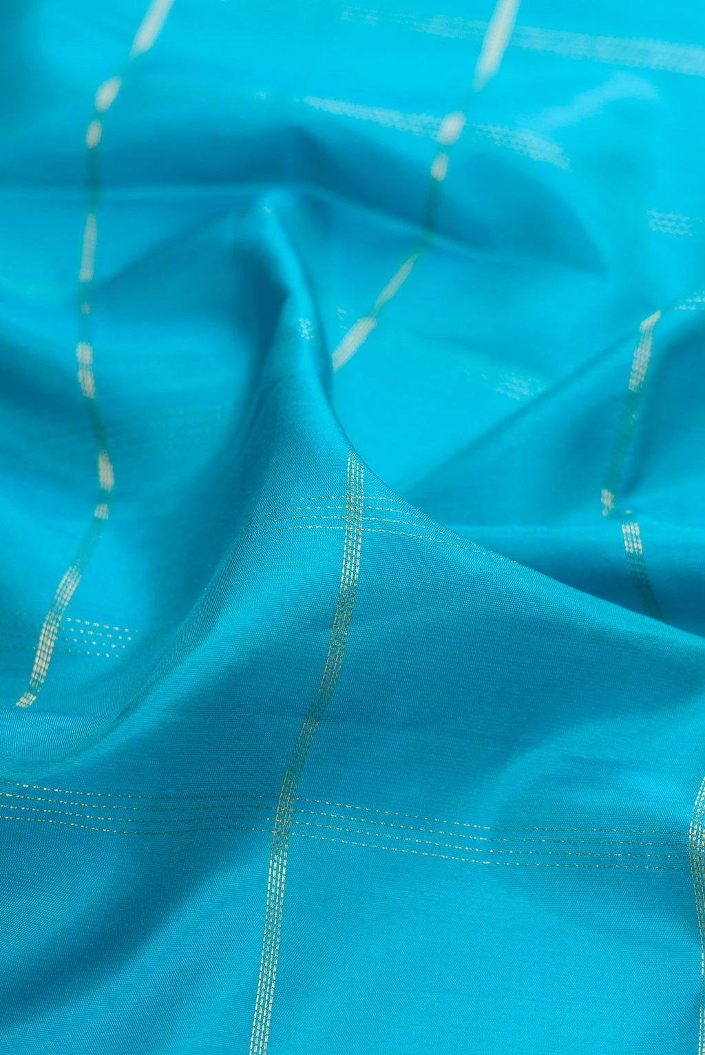 Close up of Sky Blue Soft Silk Saree with Checked design on the body and Ikat Border.  displaying folds