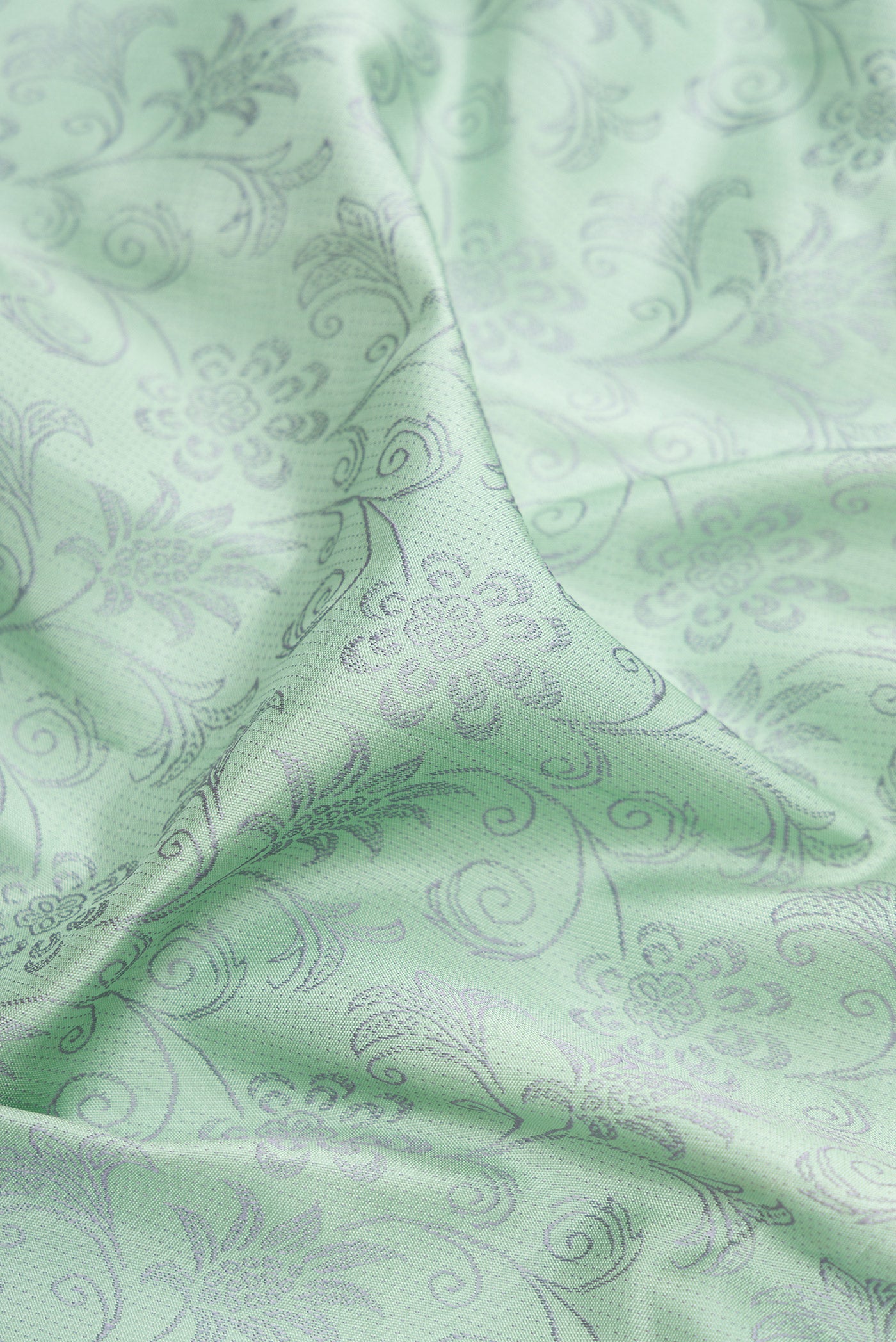 Close up of Light Green Kanchipuram Silk Saree with Jacquard design on the body and Fancy Border.  displaying folds