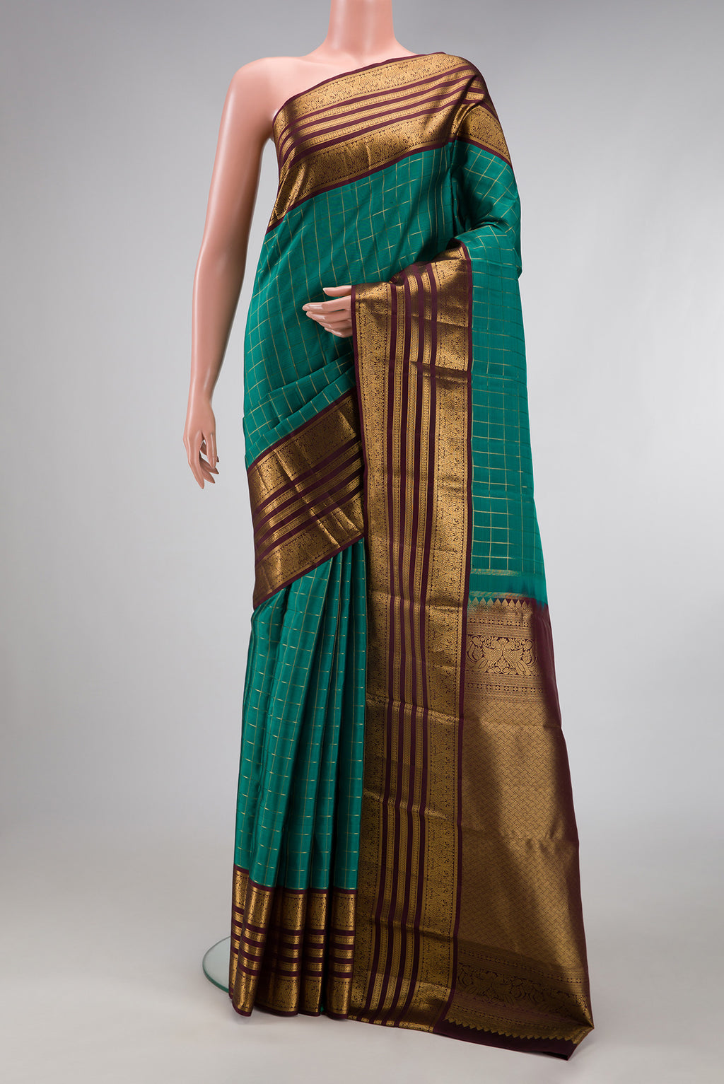 Green Kanjivaram Silk Saree with Checked design on the body and Zari Border.  displayed on a mannequin