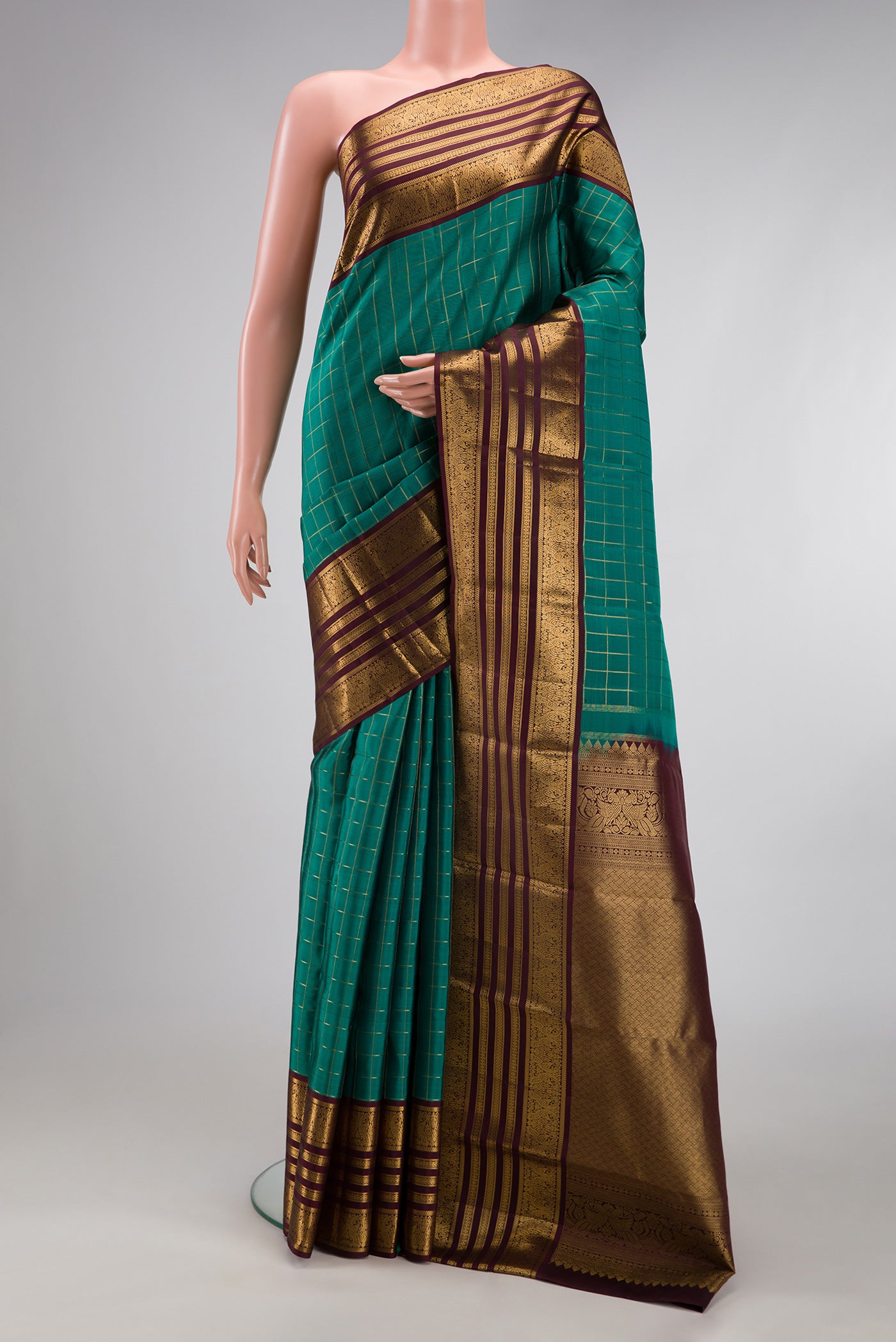Green Kanjivaram Silk Saree with Checked design on the body and Zari Border.  displayed on a mannequin