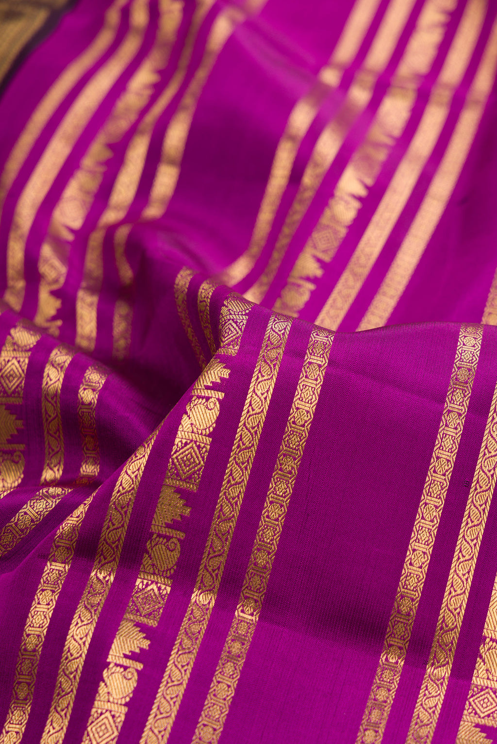 Close up of Pure Silk Magenta Kanjivaram Saree with Stripes on the body and Fancy Border.  displaying folds