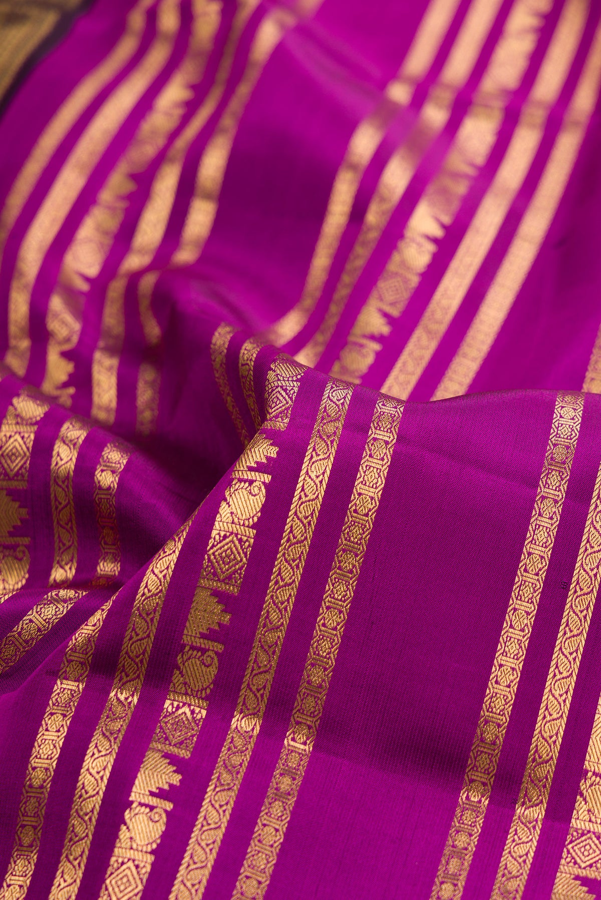 Close up of Pure Silk Magenta Kanjivaram Saree with Stripes on the body and Fancy Border.  displaying folds