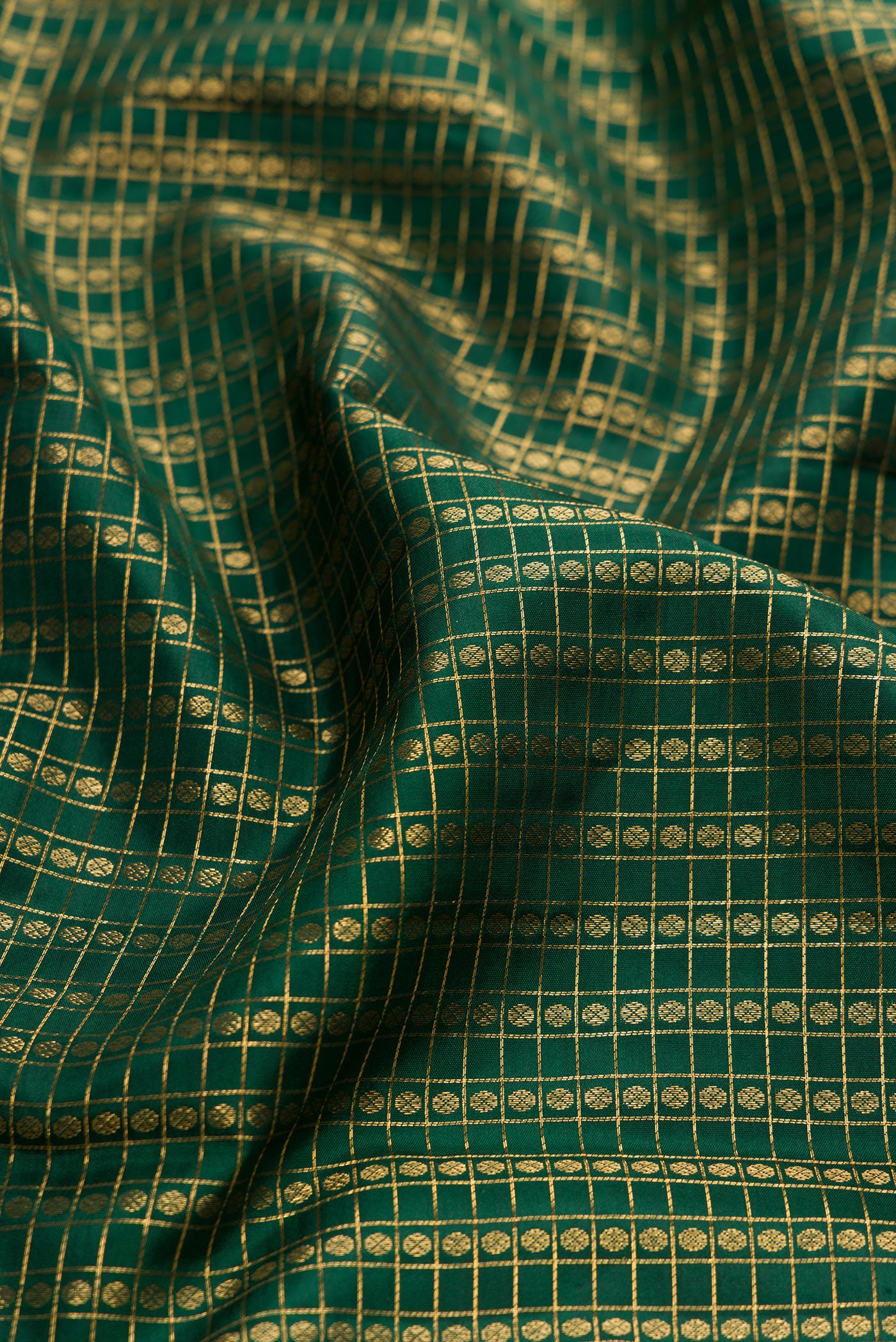 Close up of Bottle Green Kanjivaram Silk Saree with Checked design on the body and Zari Border.  displaying folds