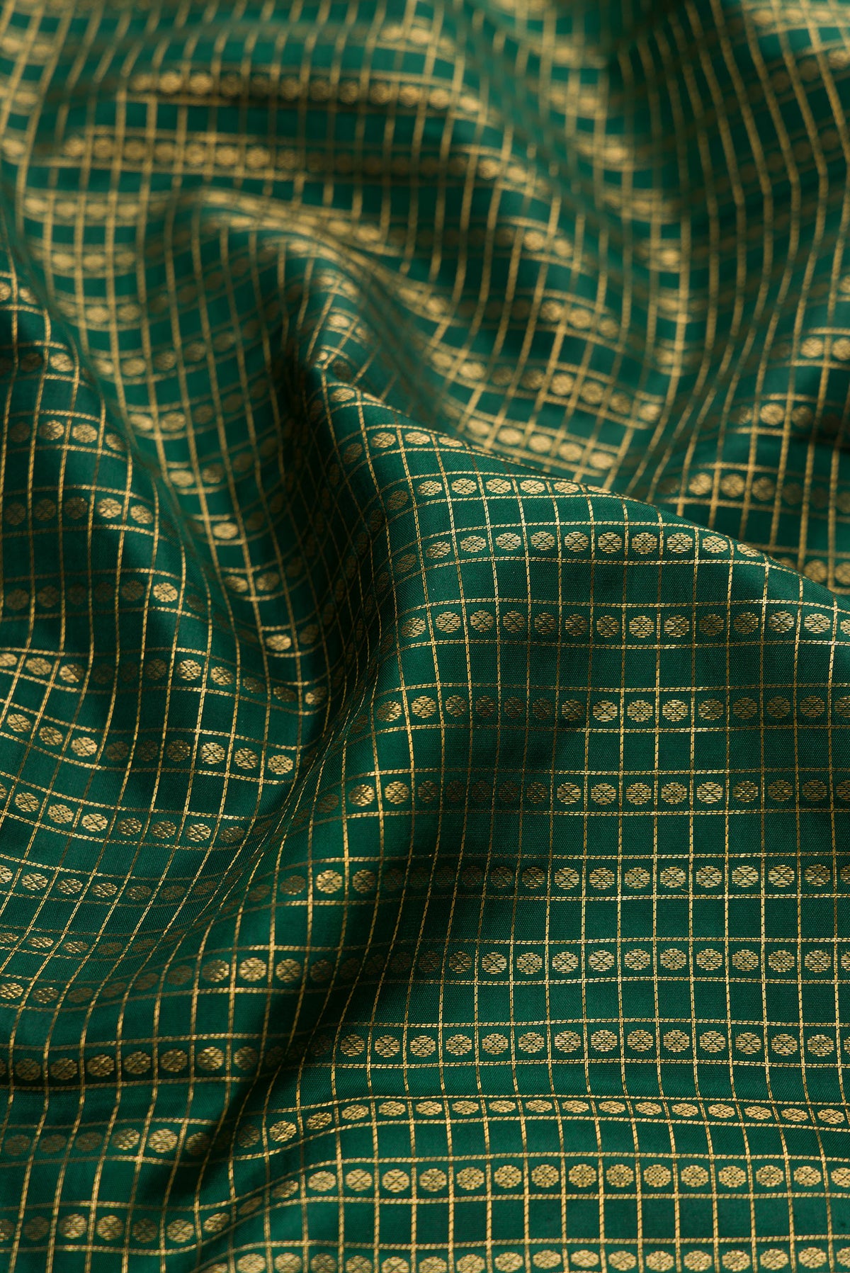 Close up of Bottle Green Kanjivaram Silk Saree with Checked design on the body and Zari Border.  displaying folds