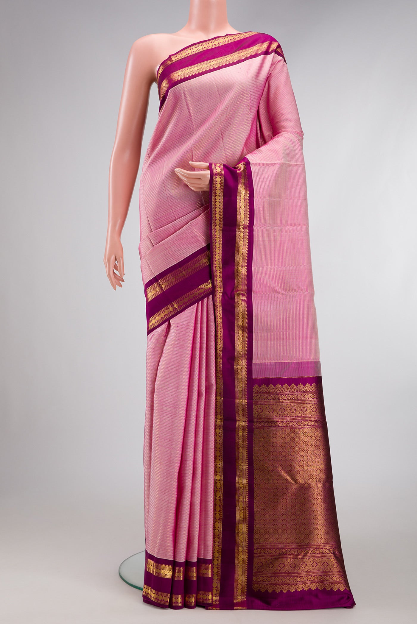 Rose pink Kanjivaram Silk Saree with Stripes on the body and Zari Border.  displayed on a mannequin