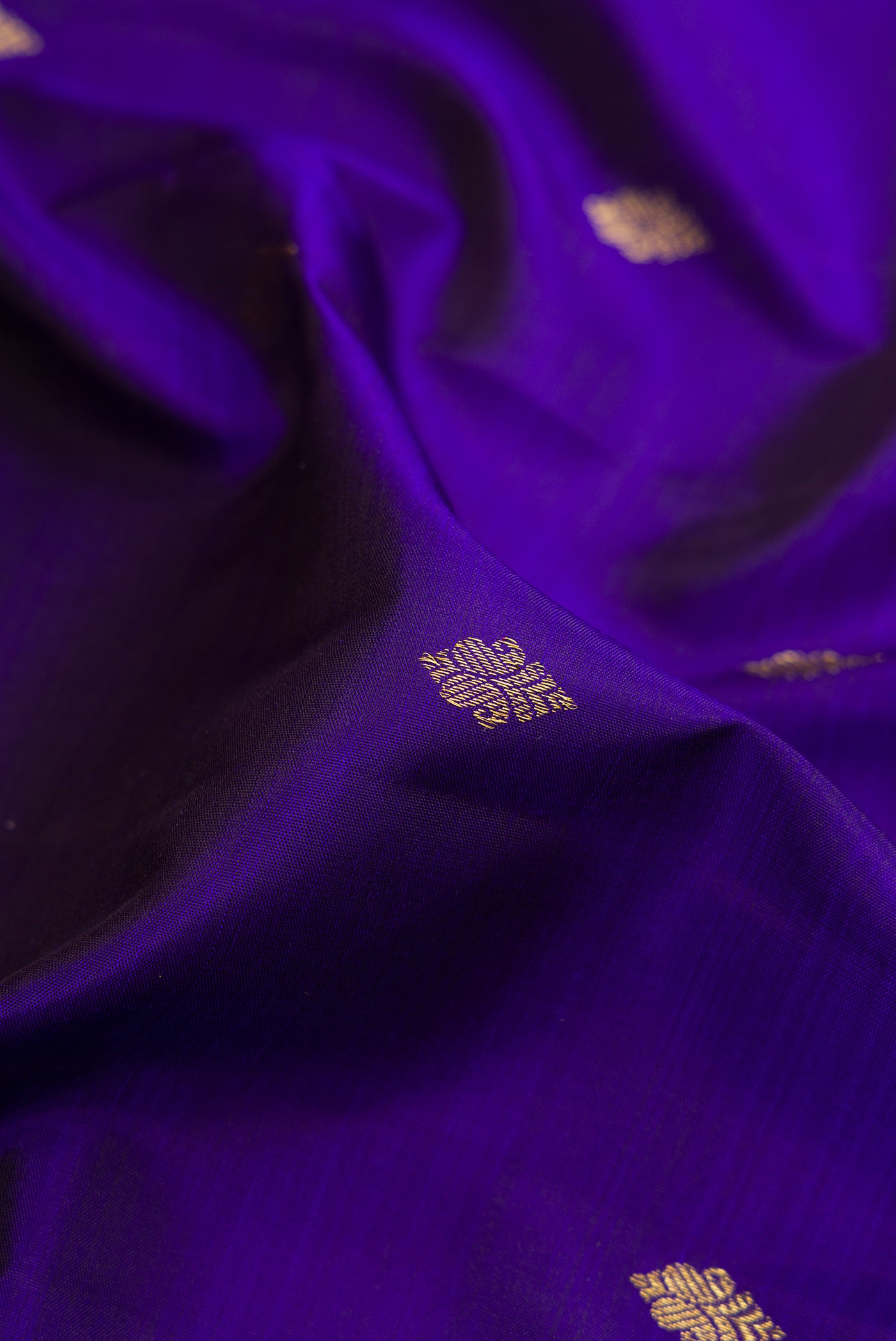 Close up of Violet Kanjivaram Silk Saree with Zari Butta on the body and Zari Border.  displaying folds
