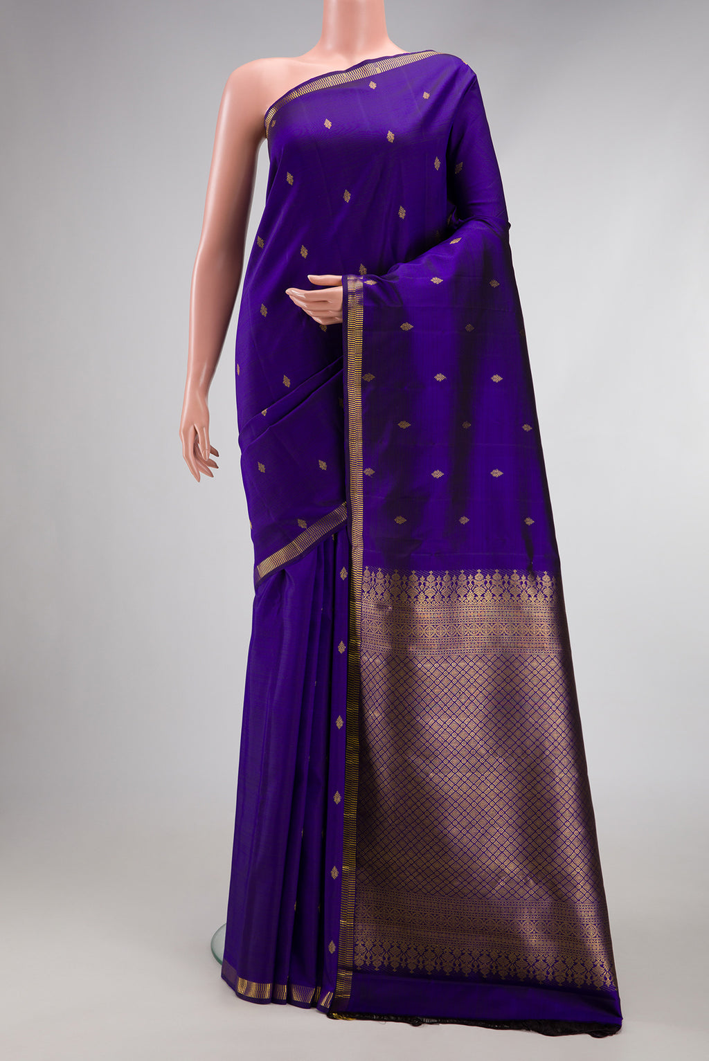 Violet Kanjivaram Silk Saree with Zari Butta on the body and Zari Border.  displayed on a mannequin