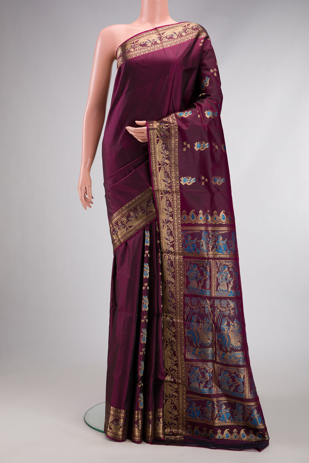 Burgundy Baluchari Silk Saree with Zari And Thread Butta on the body and Fancy Border.  displayed on a mannequin