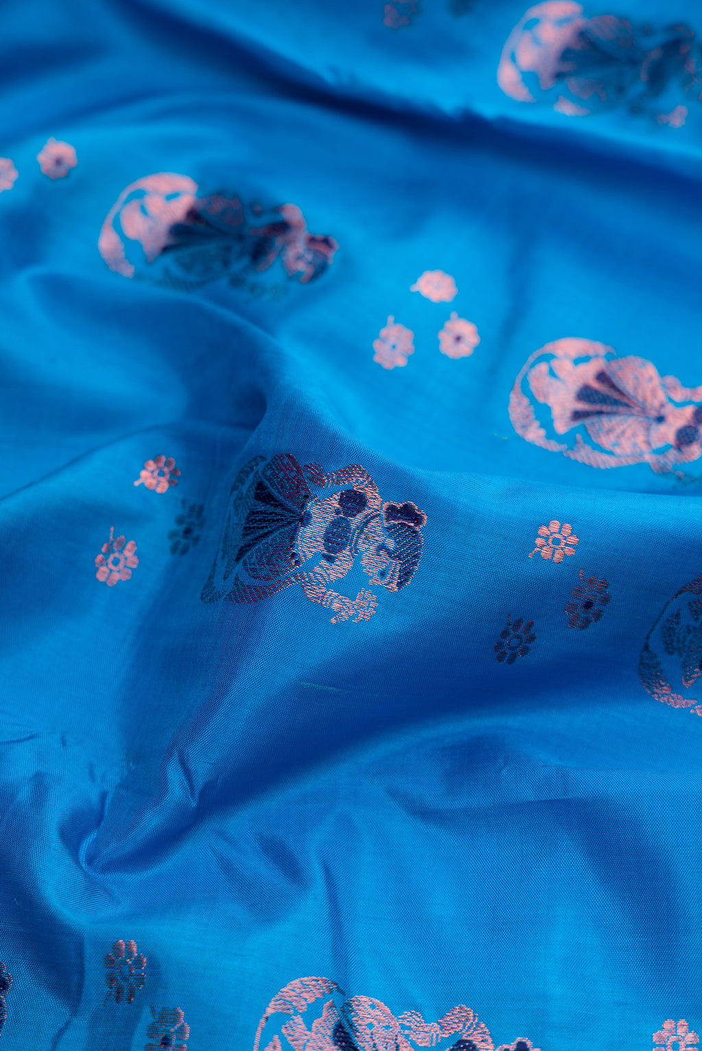 Close up of Sky Blue Dual Tone Baluchari Silk Saree with Zari And Thread Butta on the body and Fancy Border.  displaying folds