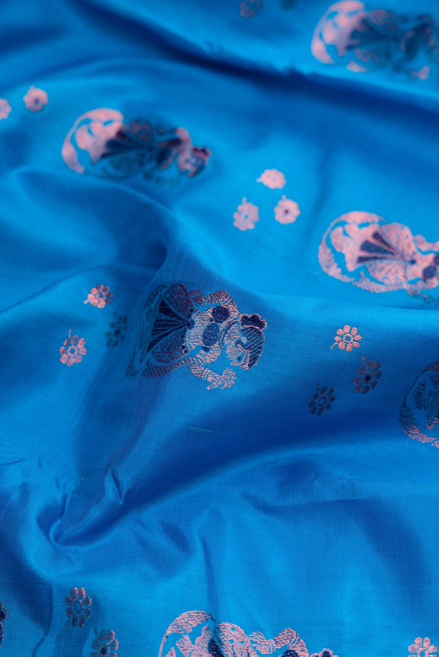 Close up of Sky Blue Dual Tone Baluchari Silk Saree with Zari And Thread Butta on the body and Fancy Border.  displaying folds