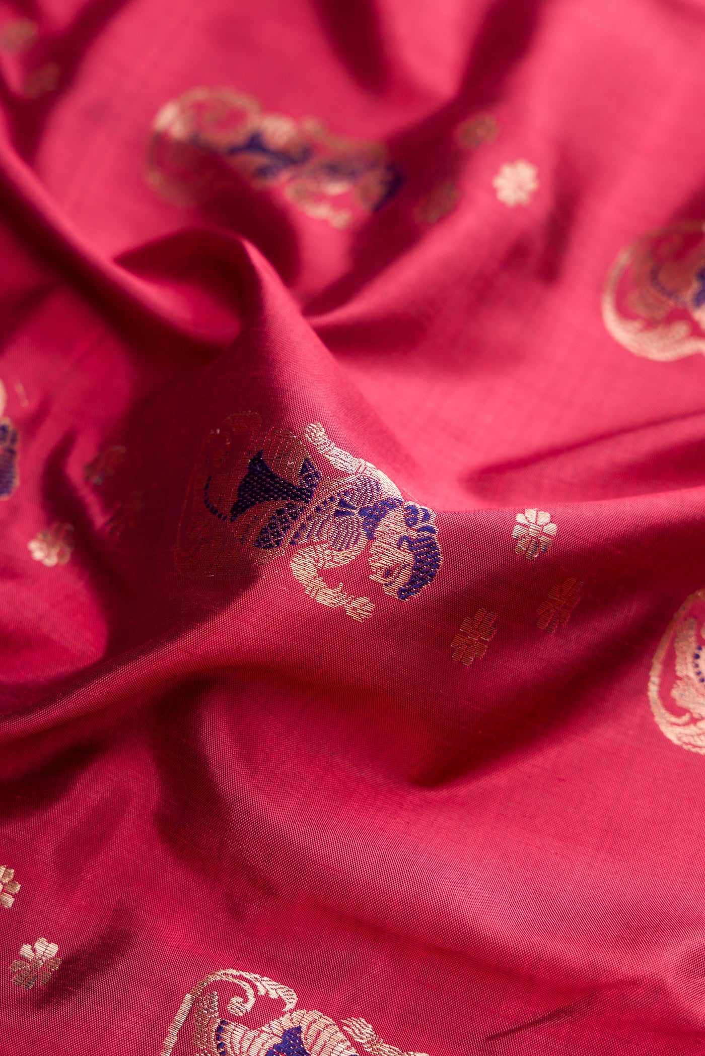Close up of Maroon Baluchari Silk Saree with Zari And Thread Butta on the body and Zari Border.  displaying folds