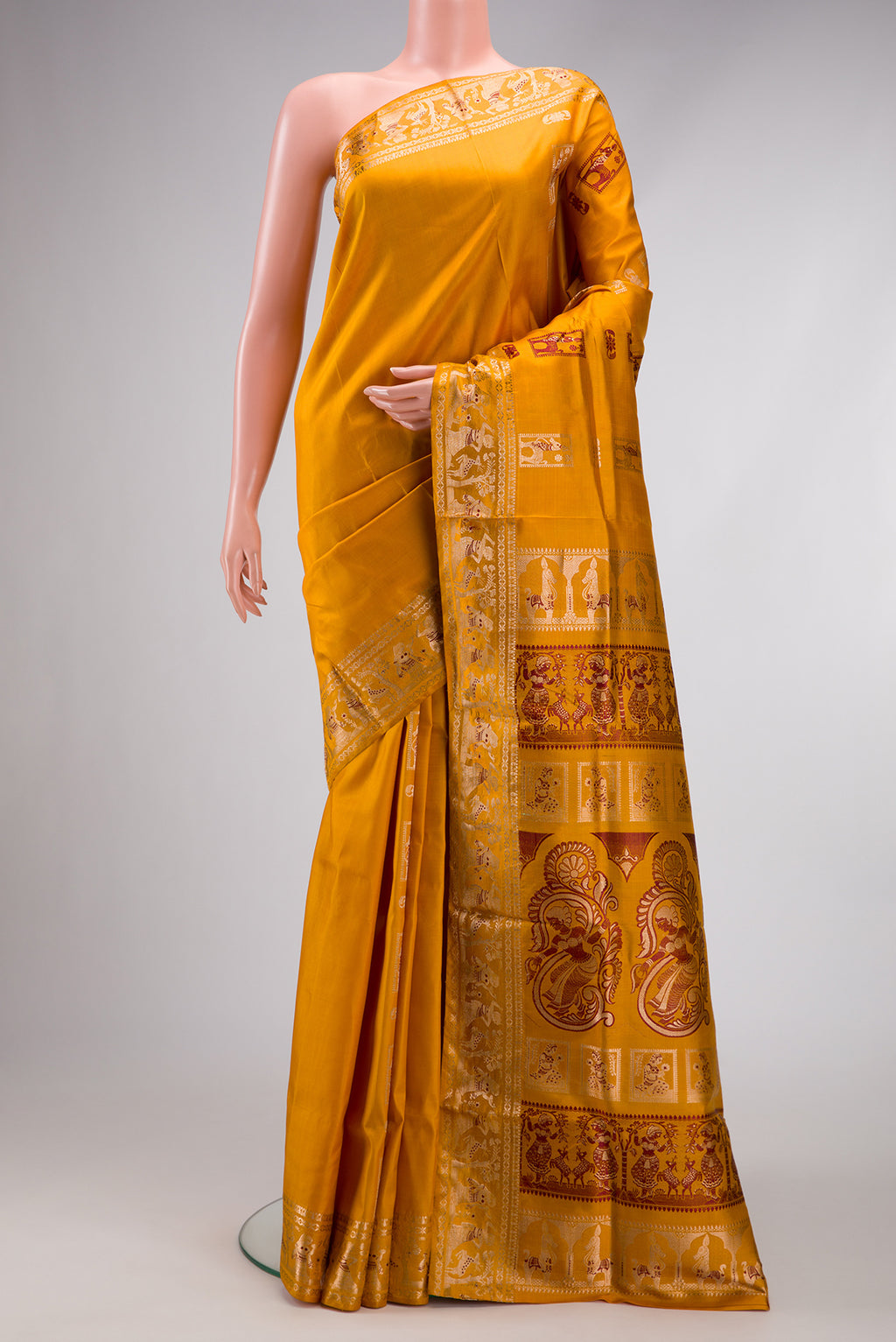 Mustard Baluchari Silk Saree with Zari And Thread Butta on the body and Zari Border.  displayed on a mannequin
