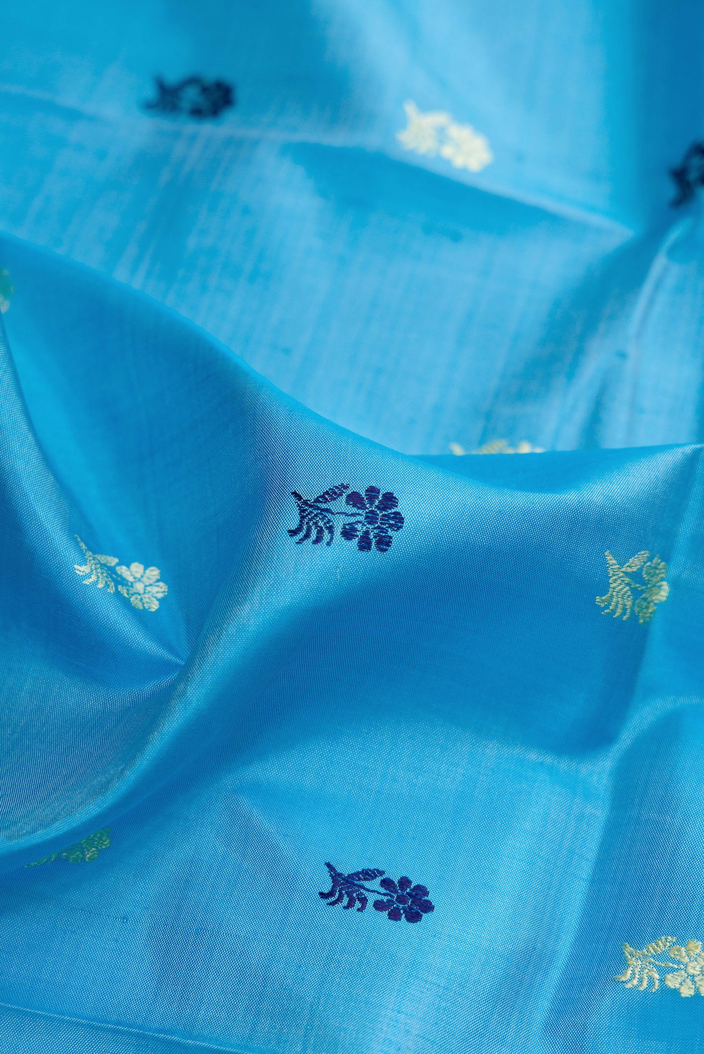 Close up of Sky Blue Dual Tone Baluchari Silk Saree with Thread Butta on the body and Thread Border.  displaying folds