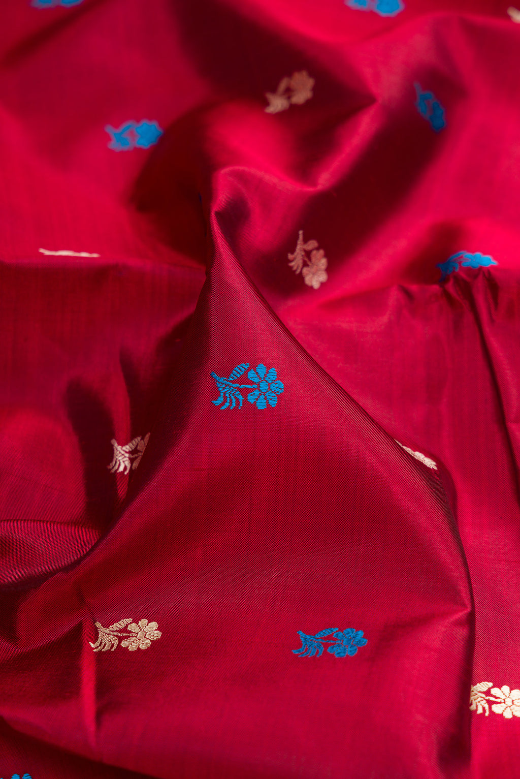 Close up of Maroon Dual Tone Baluchari Silk Saree with Thread Butta on the body and Thread Border.  displaying folds