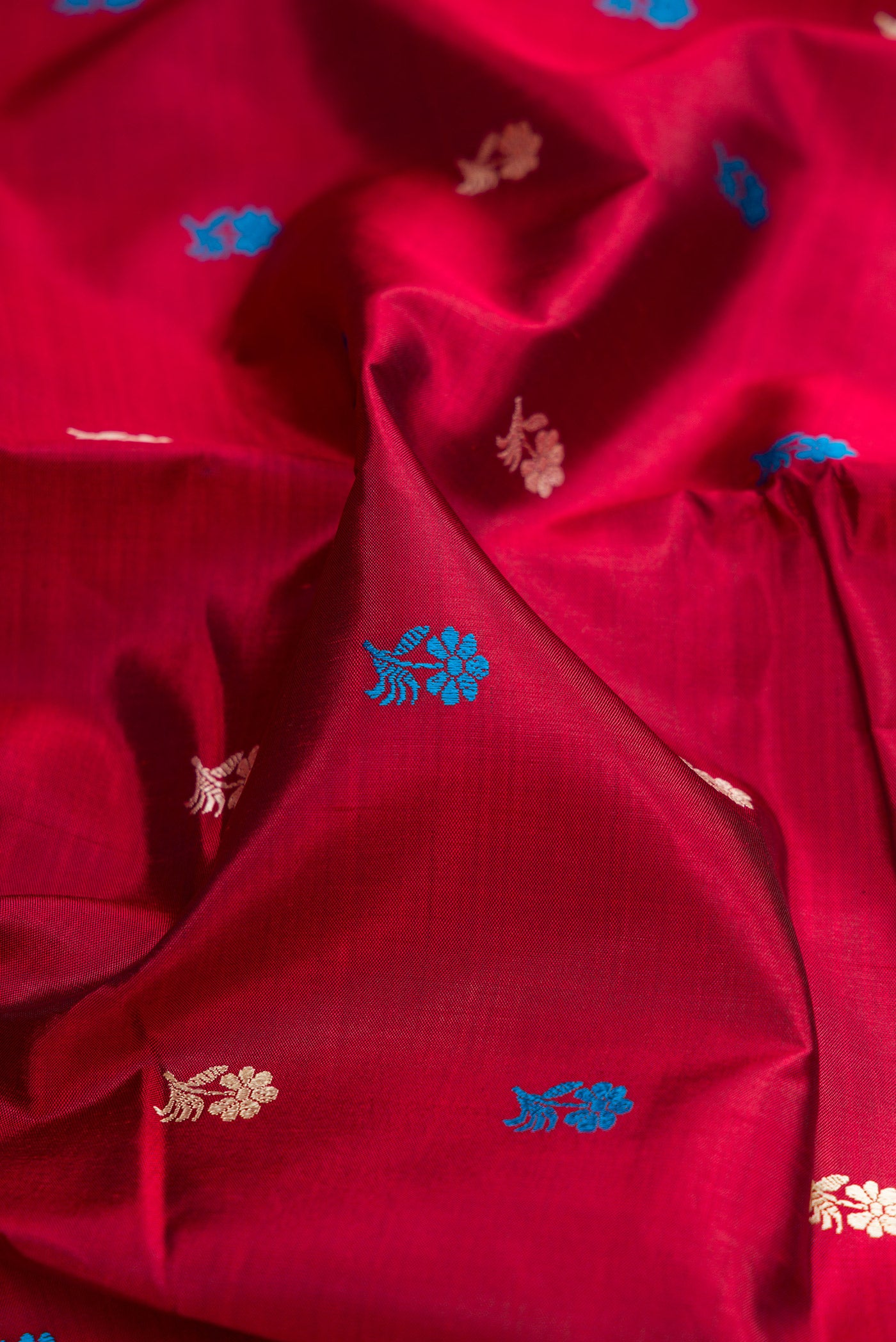Close up of Maroon Dual Tone Baluchari Silk Saree with Thread Butta on the body and Thread Border.  displaying folds
