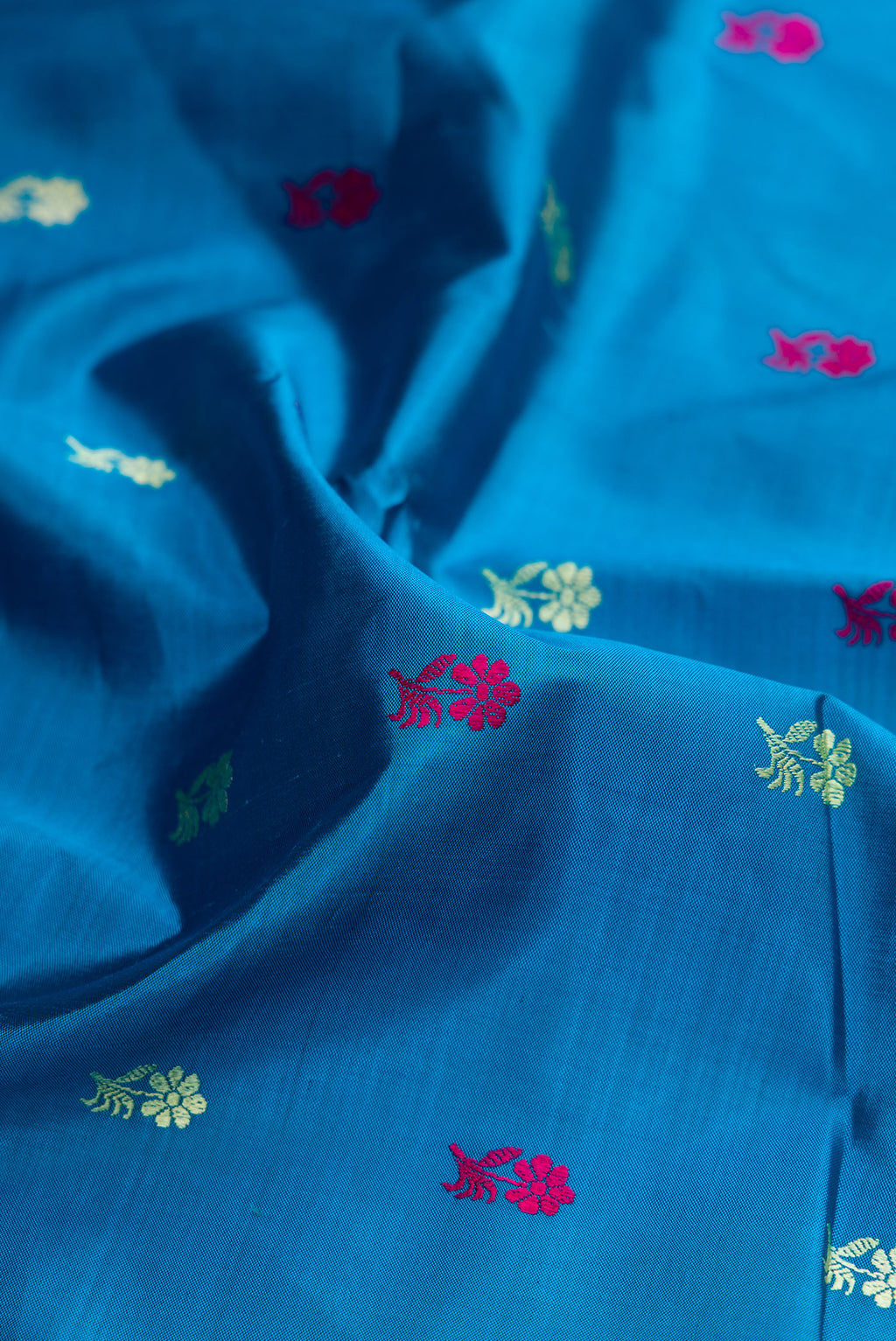 Close up of Sky Blue Baluchari Silk Saree with Thread Butta on the body and Thread Border.  displaying folds