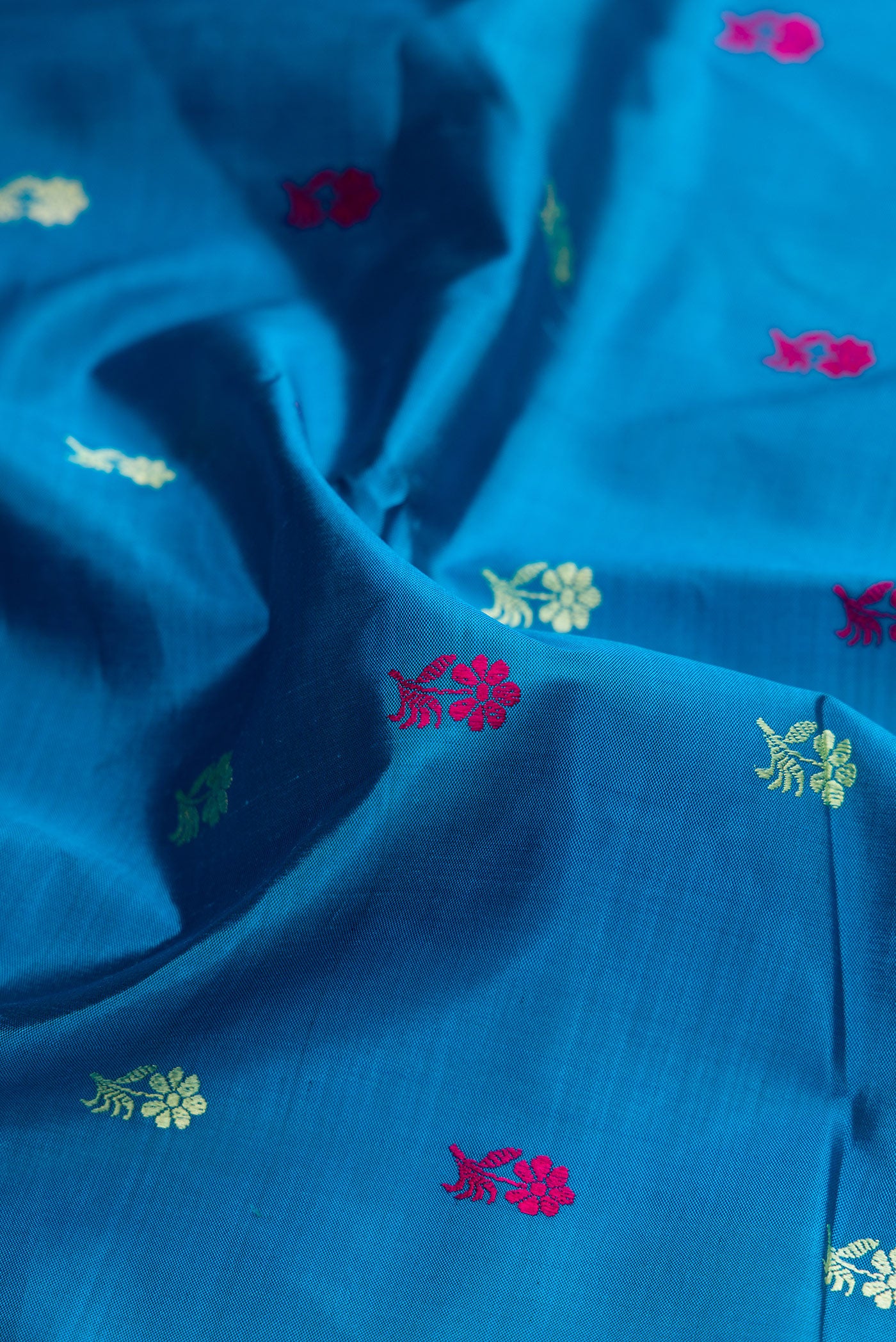 Close up of Sky Blue Baluchari Silk Saree with Thread Butta on the body and Thread Border.  displaying folds
