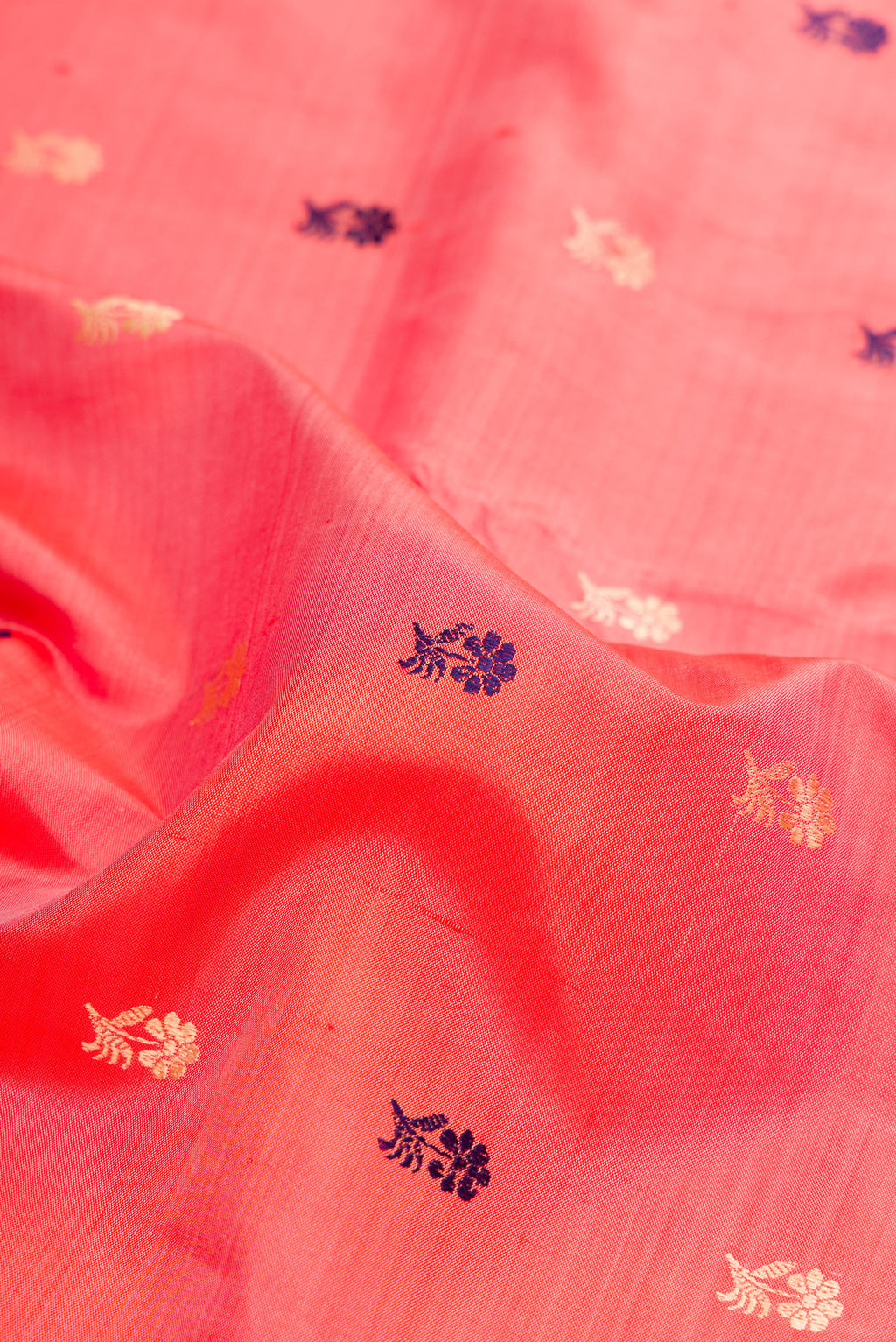 Close up of Peach Baluchari Silk Saree with Thread Butta on the body and Thread Border.  displaying folds