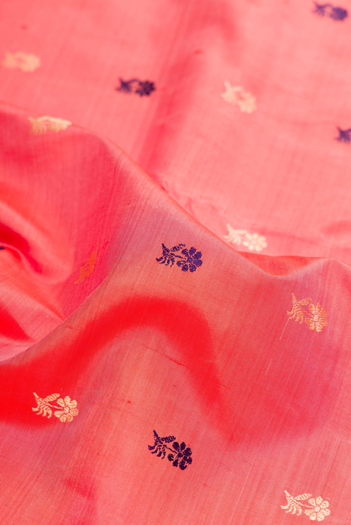 Close up of Peach Baluchari Silk Saree with Thread Butta on the body and Thread Border.  displaying folds