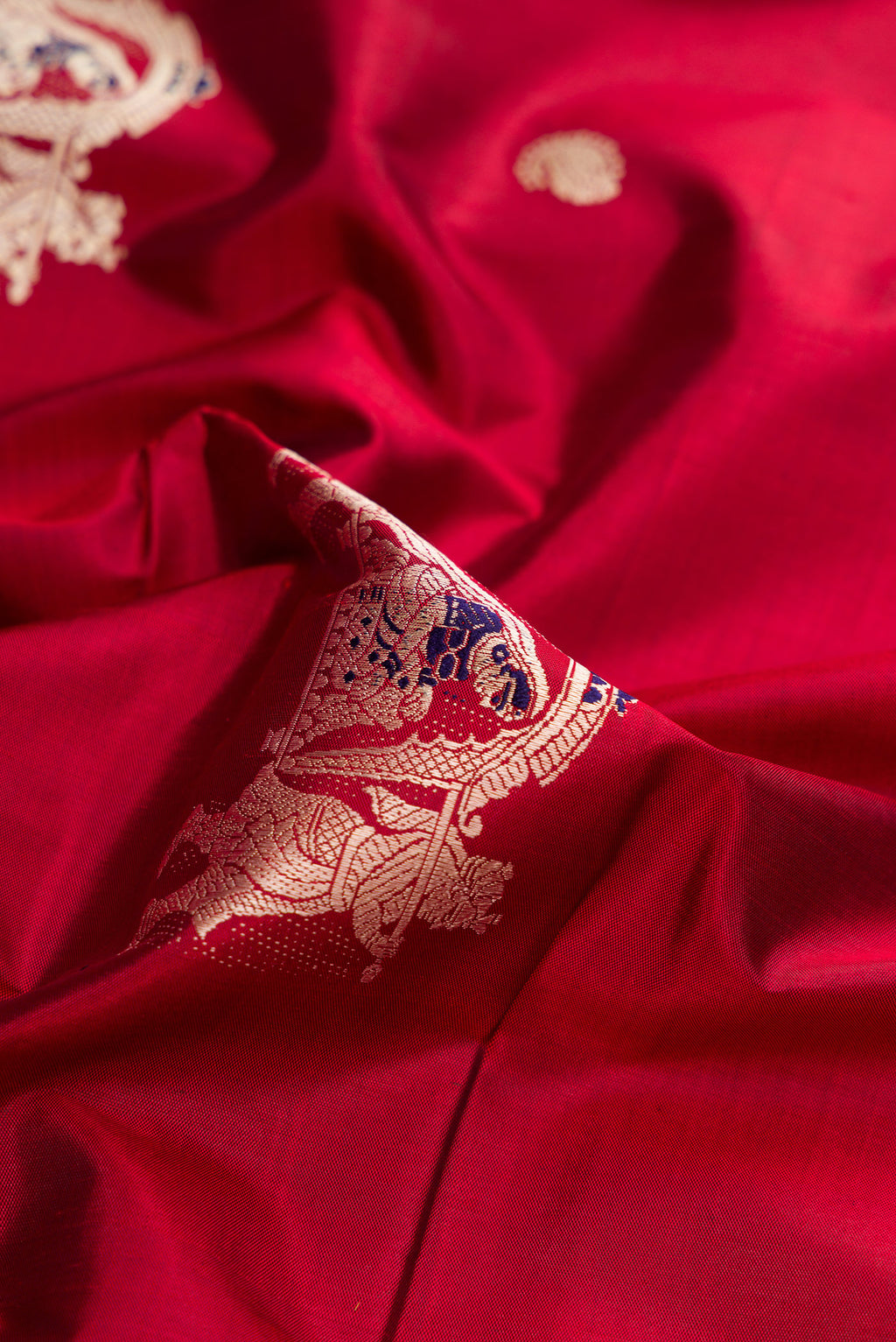 Close up of Maroon Baluchari Silk Saree with Thread Butta on the body and Thread Border.  displaying folds