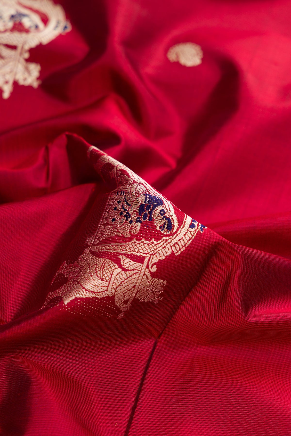 Close up of Maroon Baluchari Silk Saree with Thread Butta on the body and Thread Border.  displaying folds