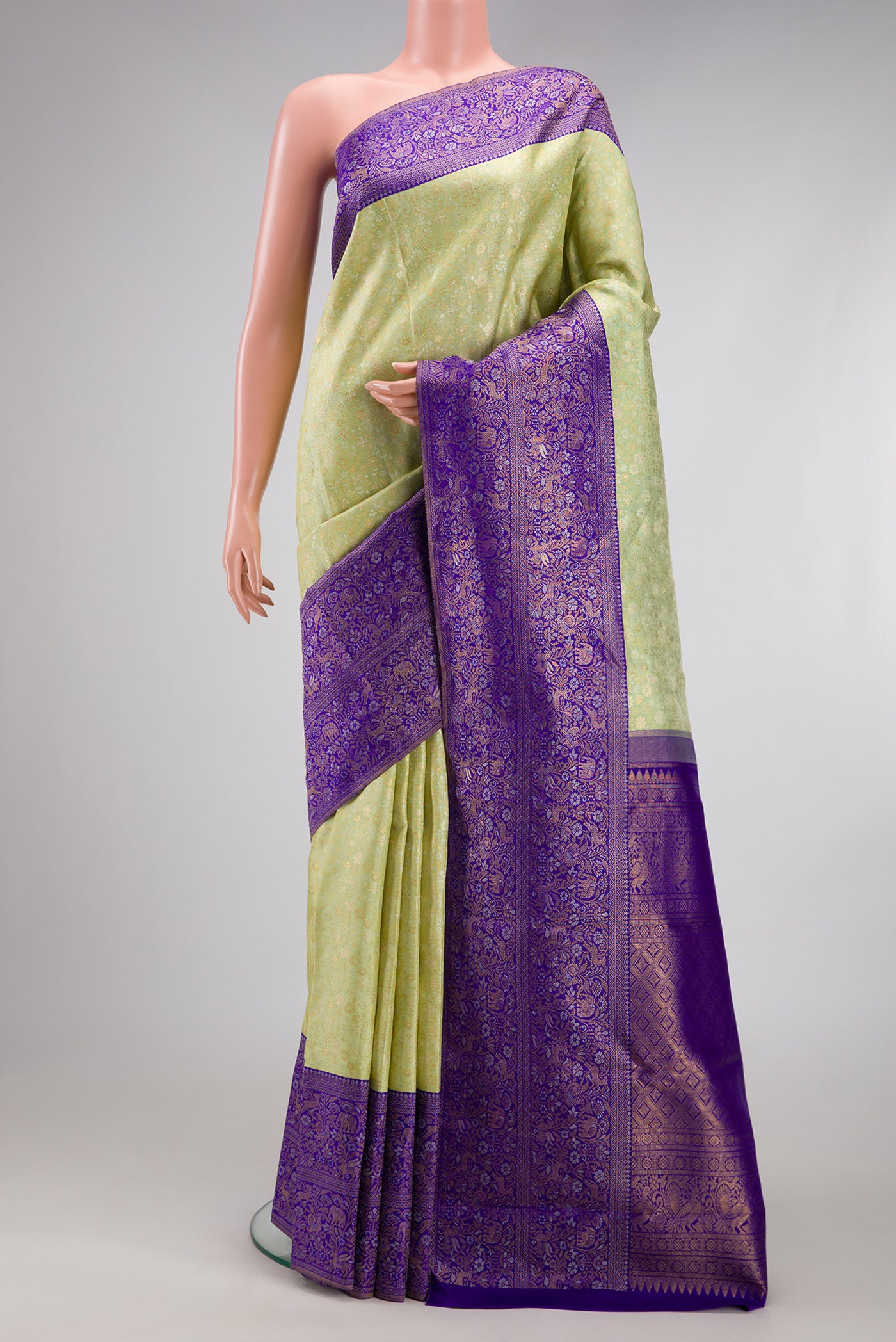 Pista Green Kanjivaram Silk Saree with Zari Brocade on the body and Fancy Border.  displayed on a mannequin