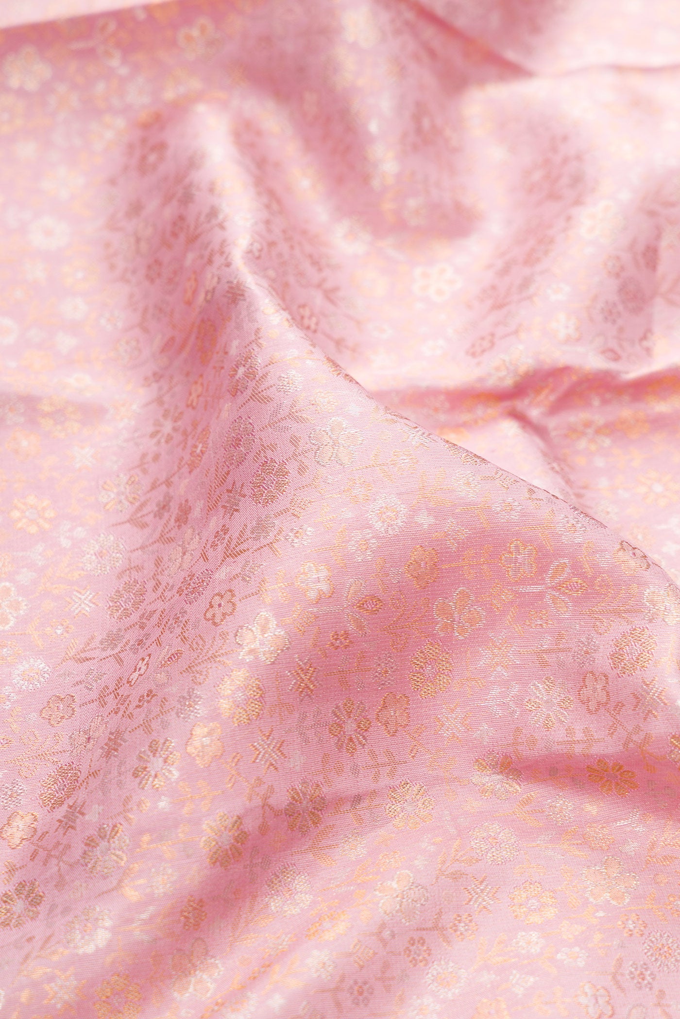 Close up of Rose Gold Kanjivaram Silk Saree with Zari Brocade on the body and Fancy Border.  displaying folds