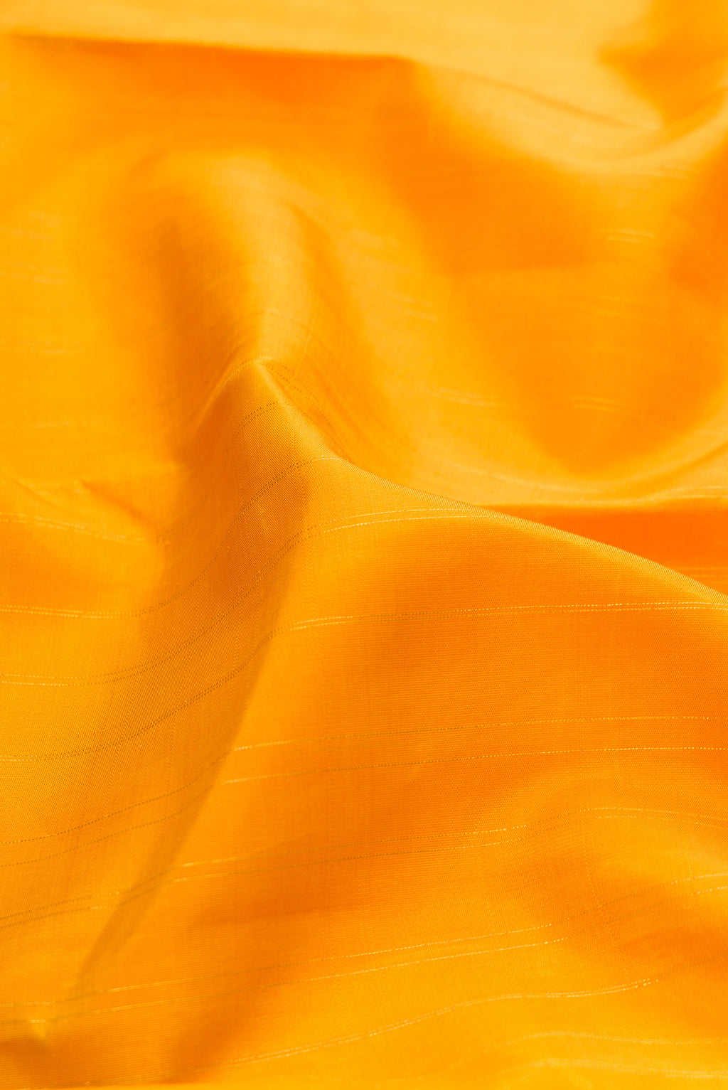 Close up of Yellow Kanchipuram Silk Saree with Stripes on the body and Fancy Border.  displaying folds