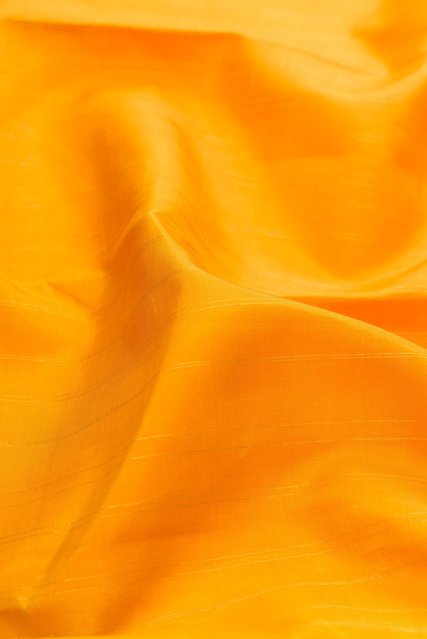 Close up of Yellow Kanchipuram Silk Saree with Stripes on the body and Fancy Border.  displaying folds