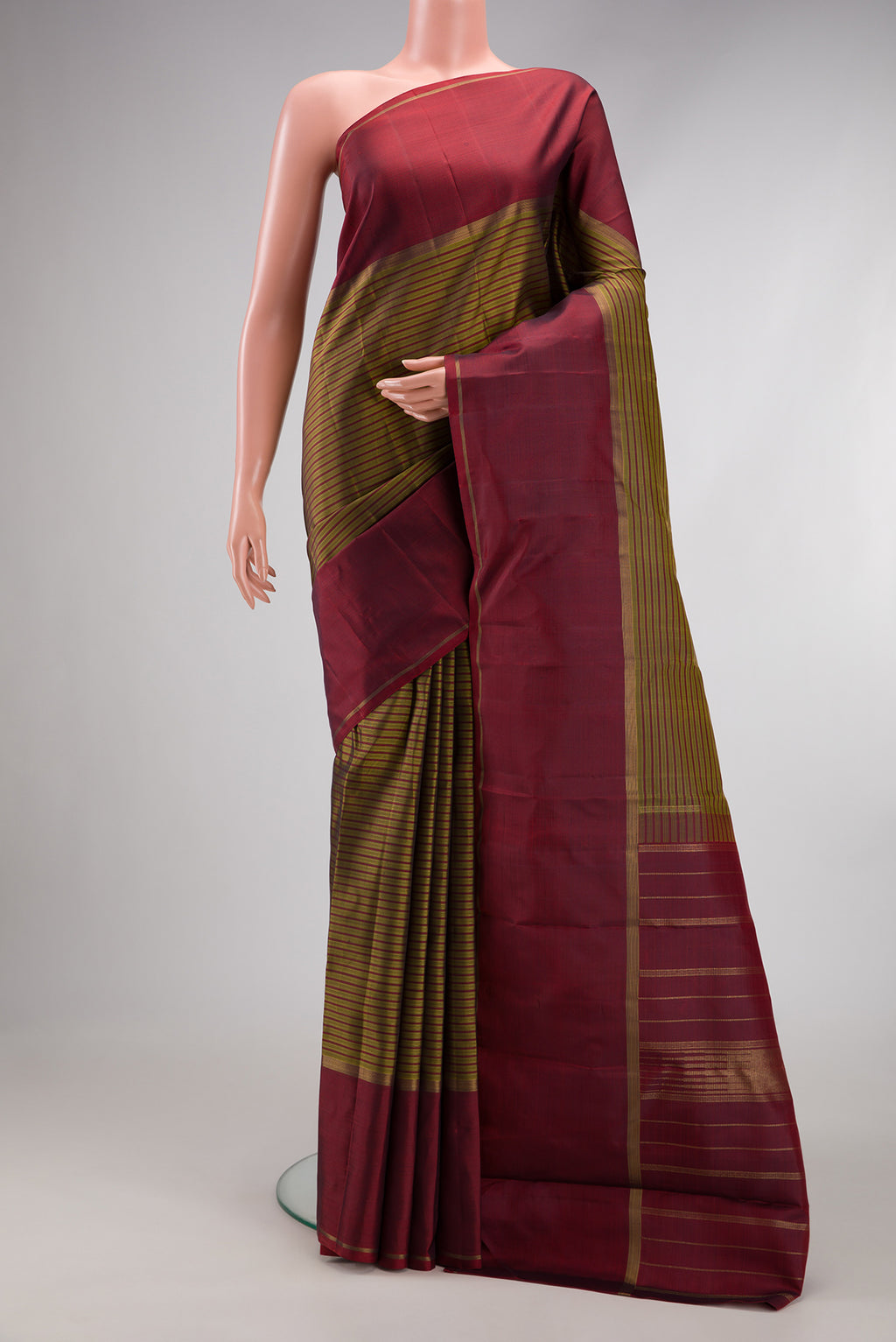 Pure Silk Pure Zari Mehandi Green Kanchipuram Saree with Stripes on the body and Plain Border.  displayed on a mannequin