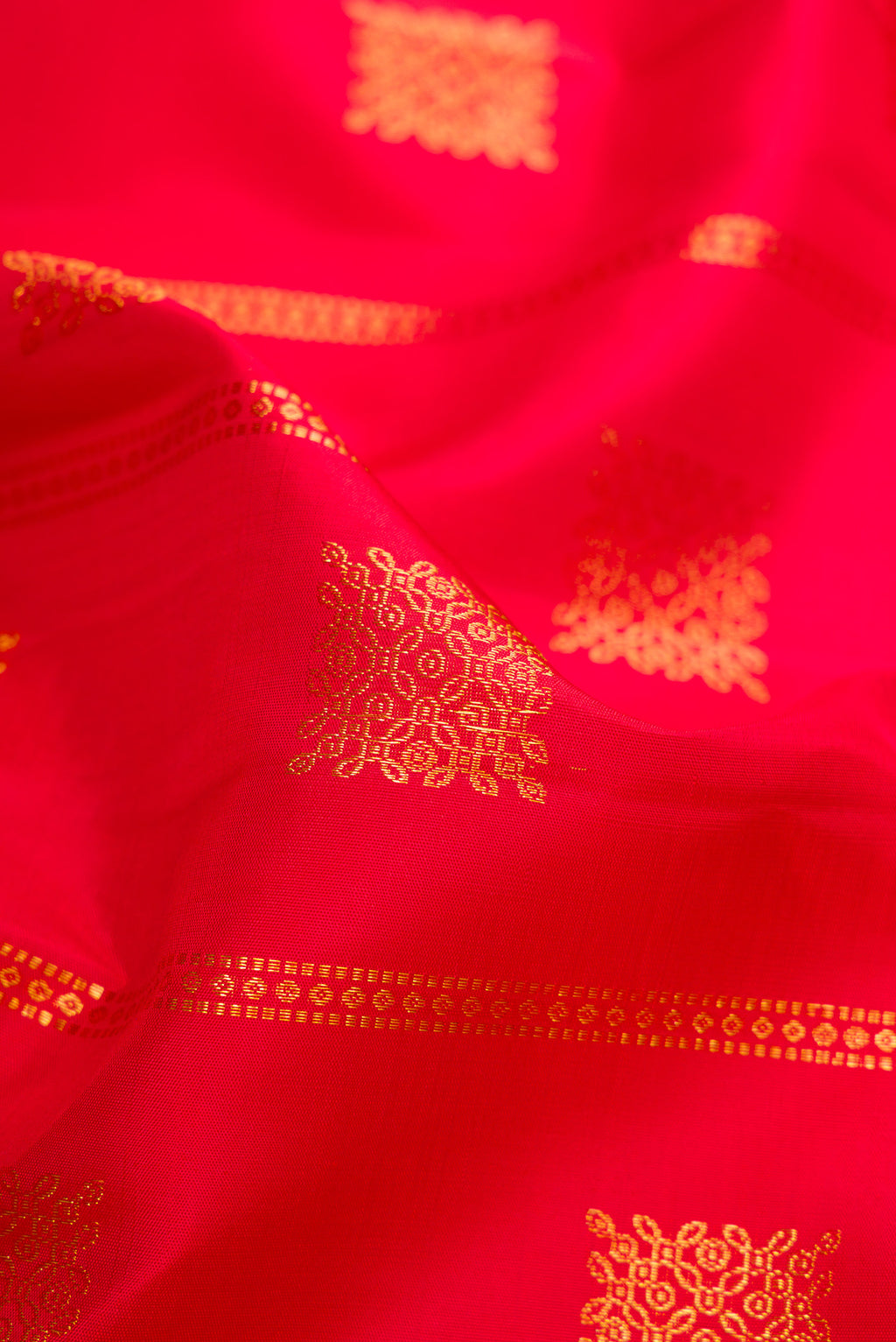 Close up of Red Kanjivaram Silk Saree with Zari Butta on the body and Zari Border.  displaying folds