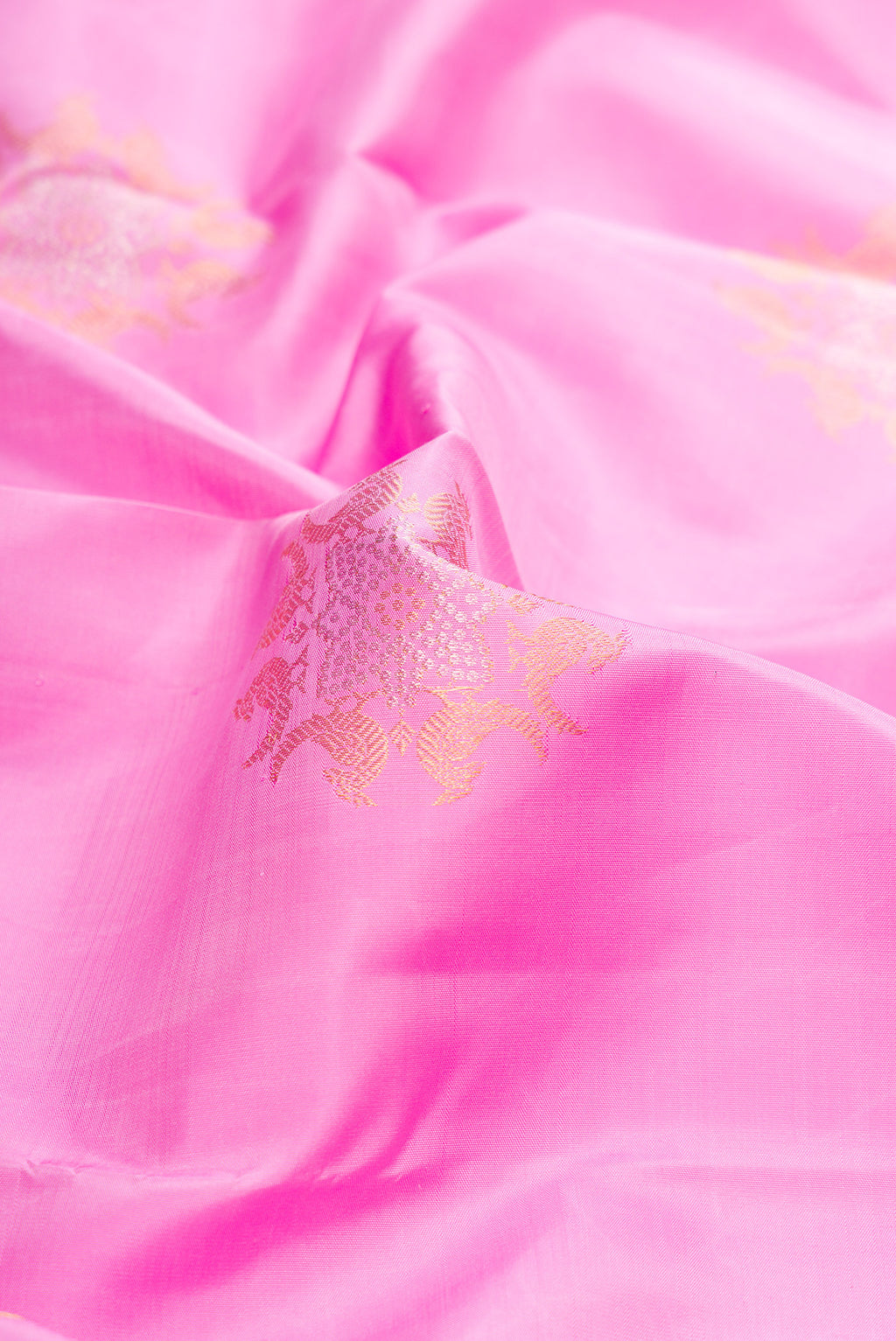 Close up of Rose pink Kanjivaram Silk Saree with Zari Butta on the body and Zari Border.  displaying folds