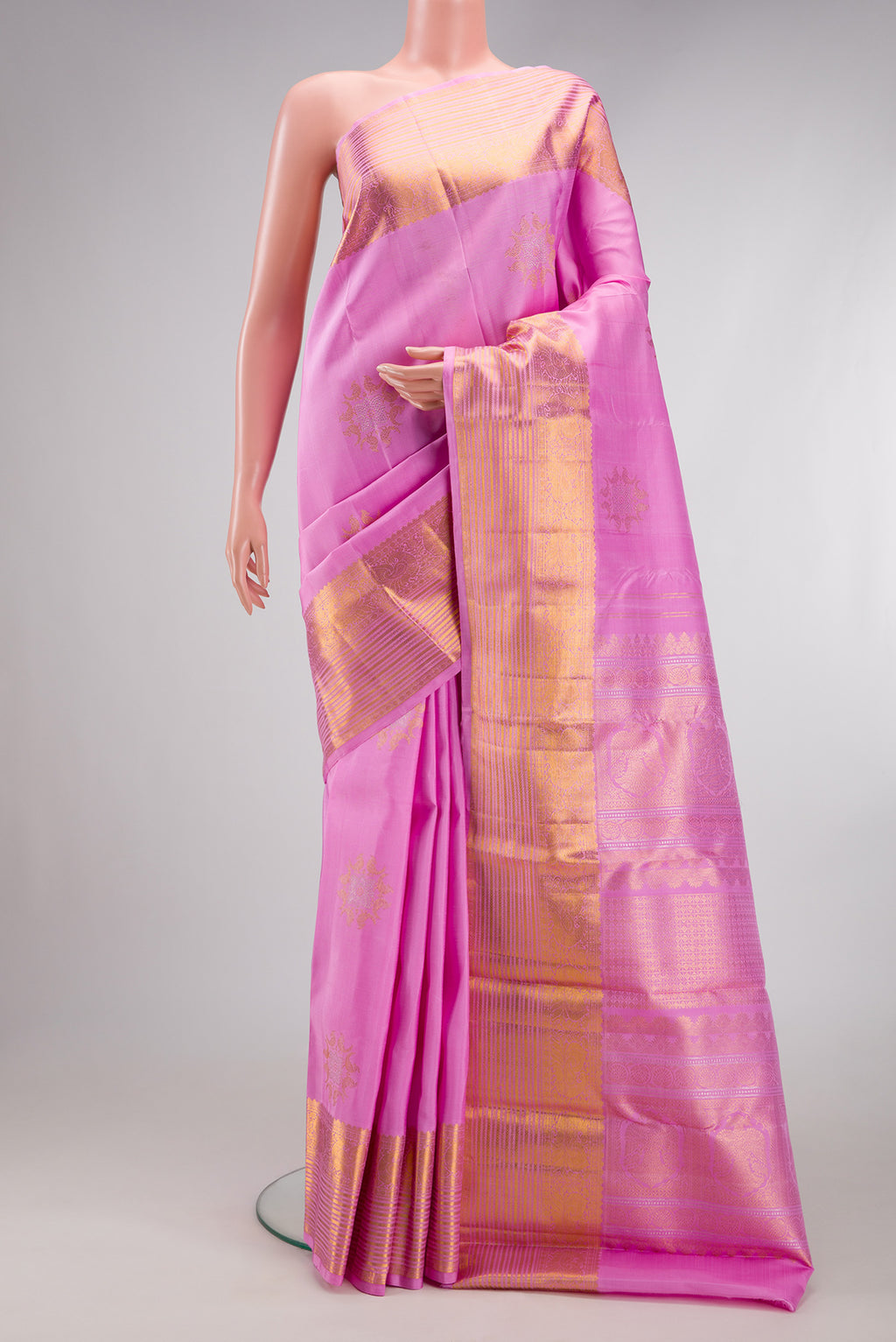 Rose pink Kanjivaram Silk Saree with Zari Butta on the body and Zari Border.  displayed on a mannequin
