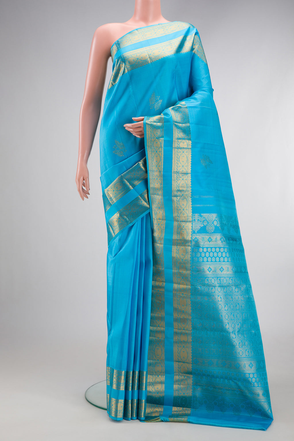 Sky Blue Kanjivaram Silk Saree with Zari Butta on the body and Zari Border.  displayed on a mannequin