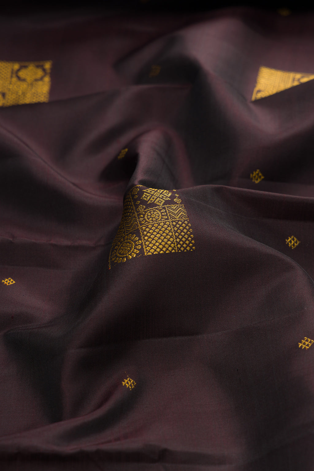 Close up of Coffee Brown Kanjivaram Silk Saree with Zari Butta on the body and Zari Border.  displaying folds