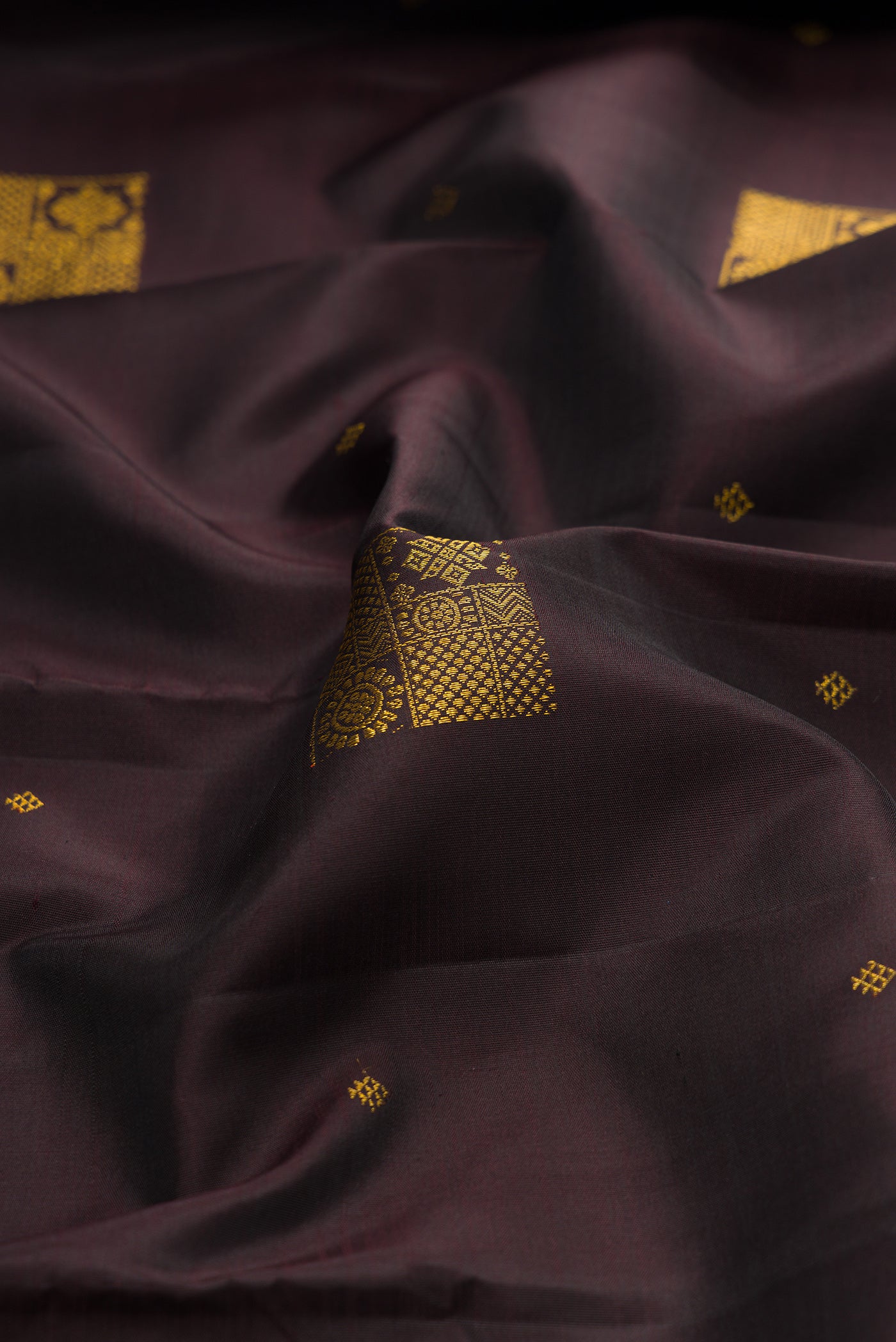 Close up of Coffee Brown Kanjivaram Silk Saree with Zari Butta on the body and Zari Border.  displaying folds