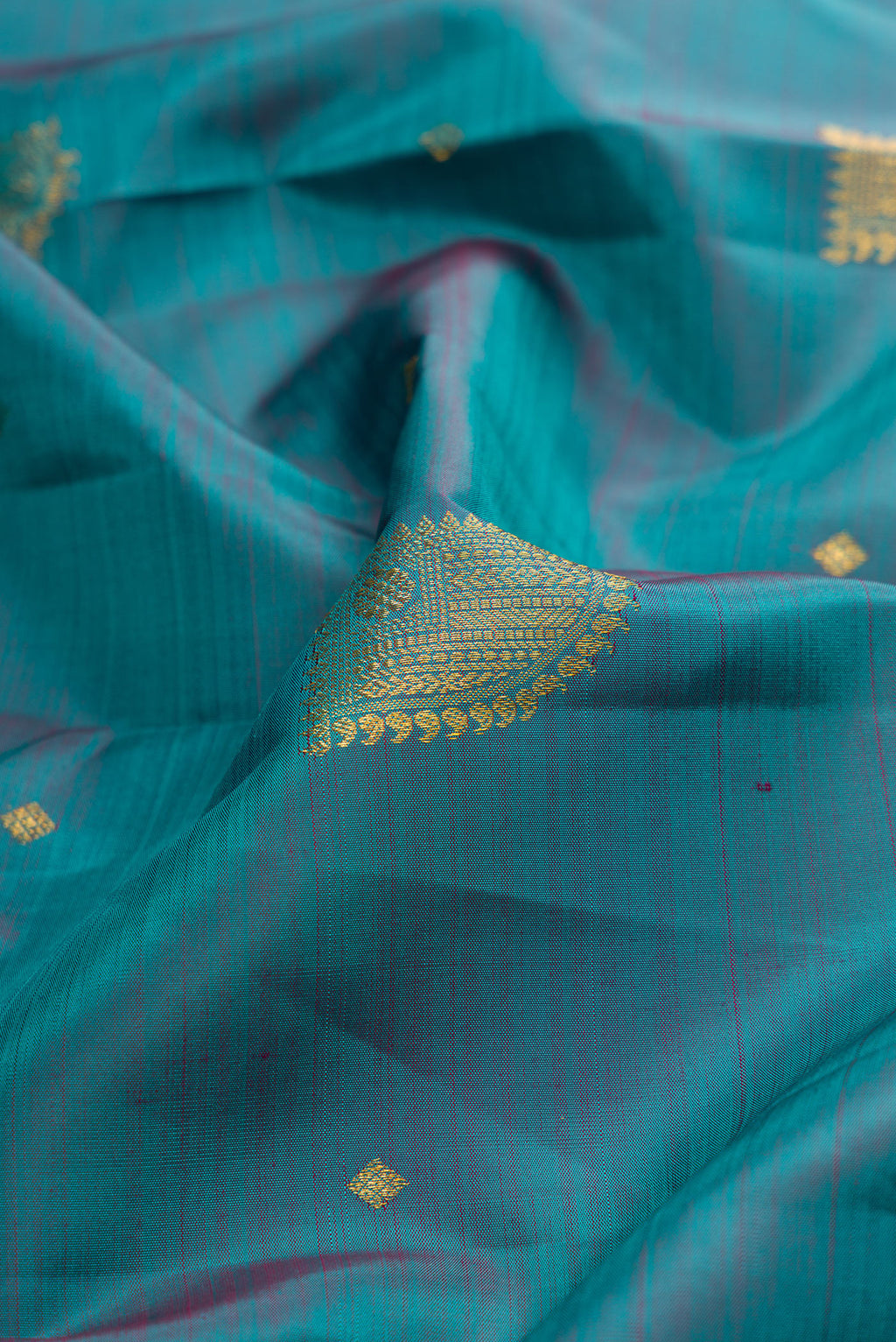 Close up of Maya Blue Dual Tone Kanjivaram Silk Saree with Zari Butta on the body and Zari Border.  displaying folds