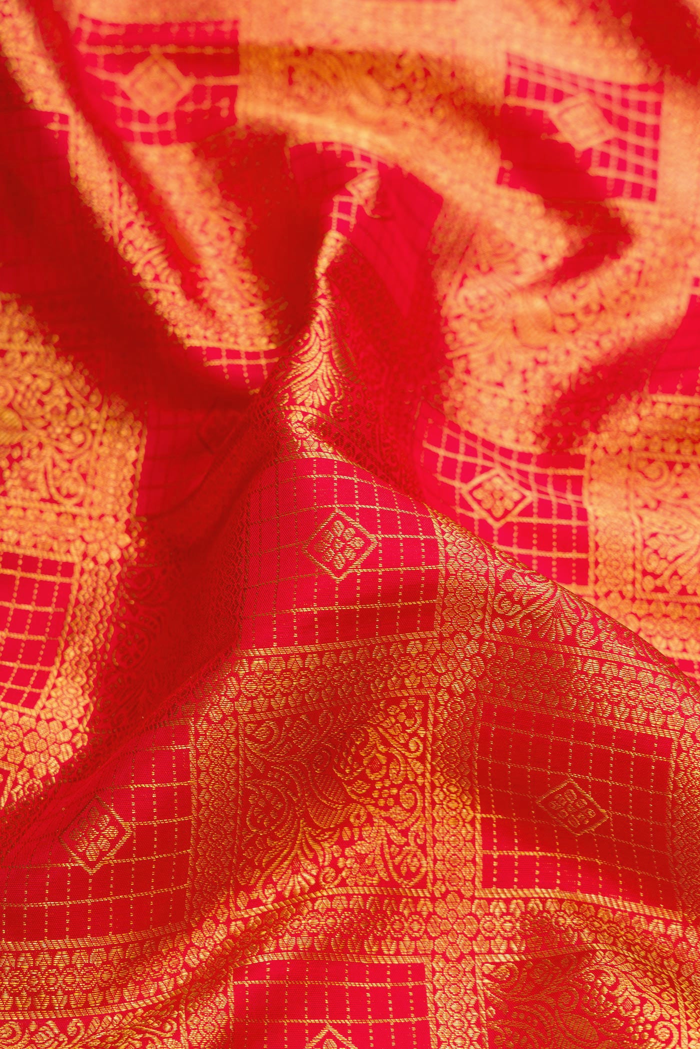 Close up of Red Kanchipuram Silk Saree with Zari Brocade on the body and Zari Border.  displaying folds