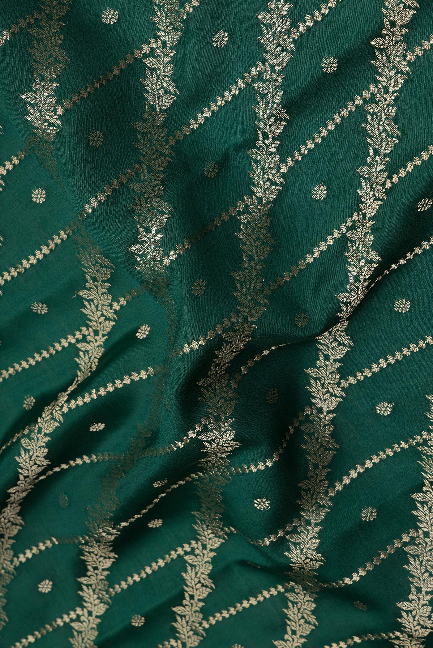 Close up of Bottle Green Crepe Saree with Zari Brocade on the body and Zari Border.  displaying folds