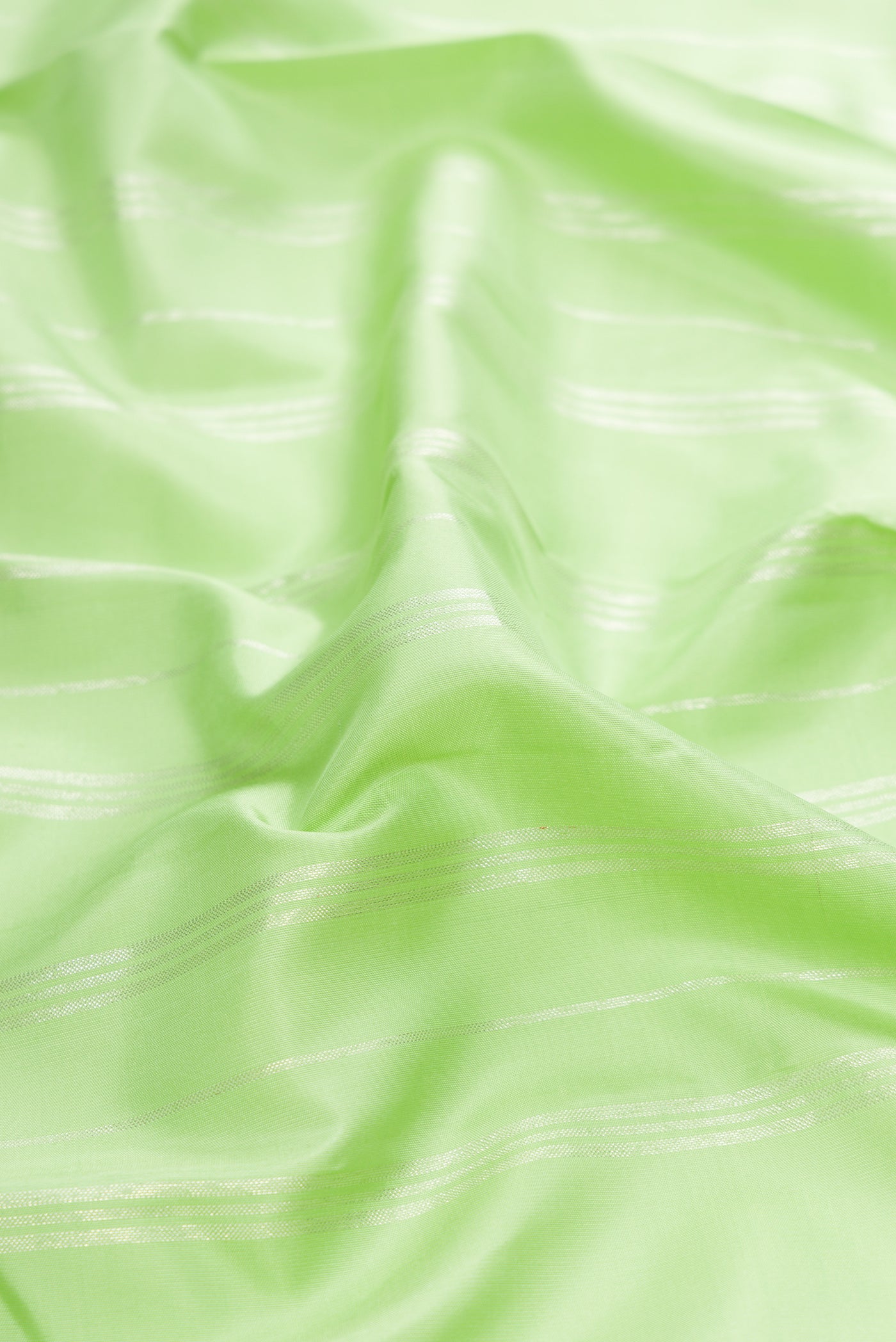 Close up of Pista Green Kanjivaram Silk Saree with Stripes on the body and Fancy Border.  displaying folds